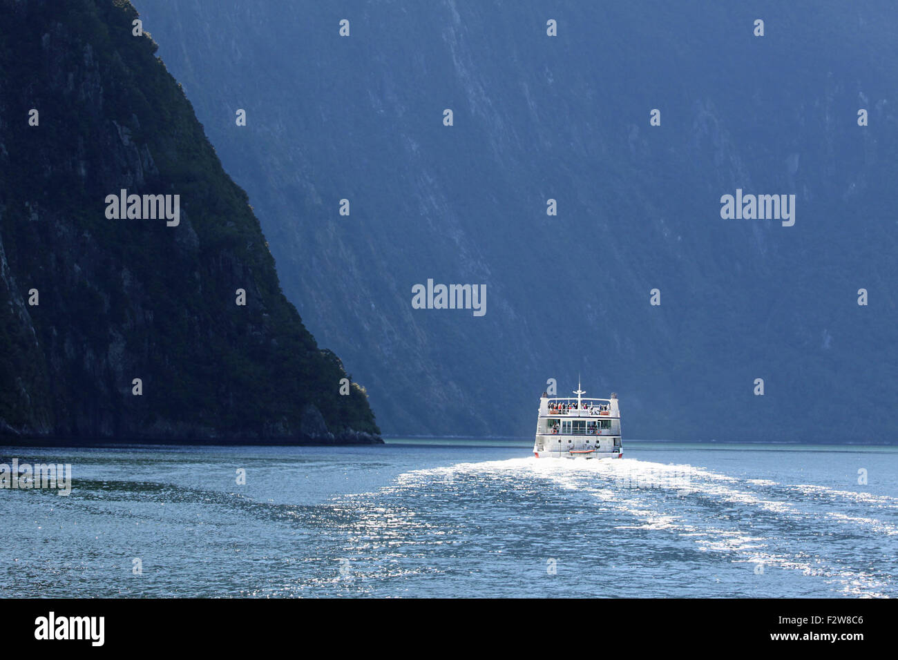 Sightseeing boat sailing in Milford Sound, New Zealand. Stock Photo