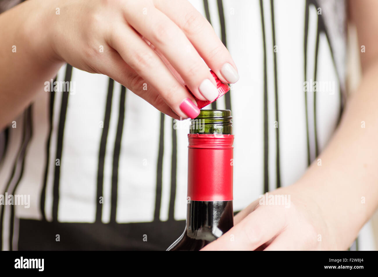 Female hand unscrews the screw cap red wine bottle Stock Photo Alamy