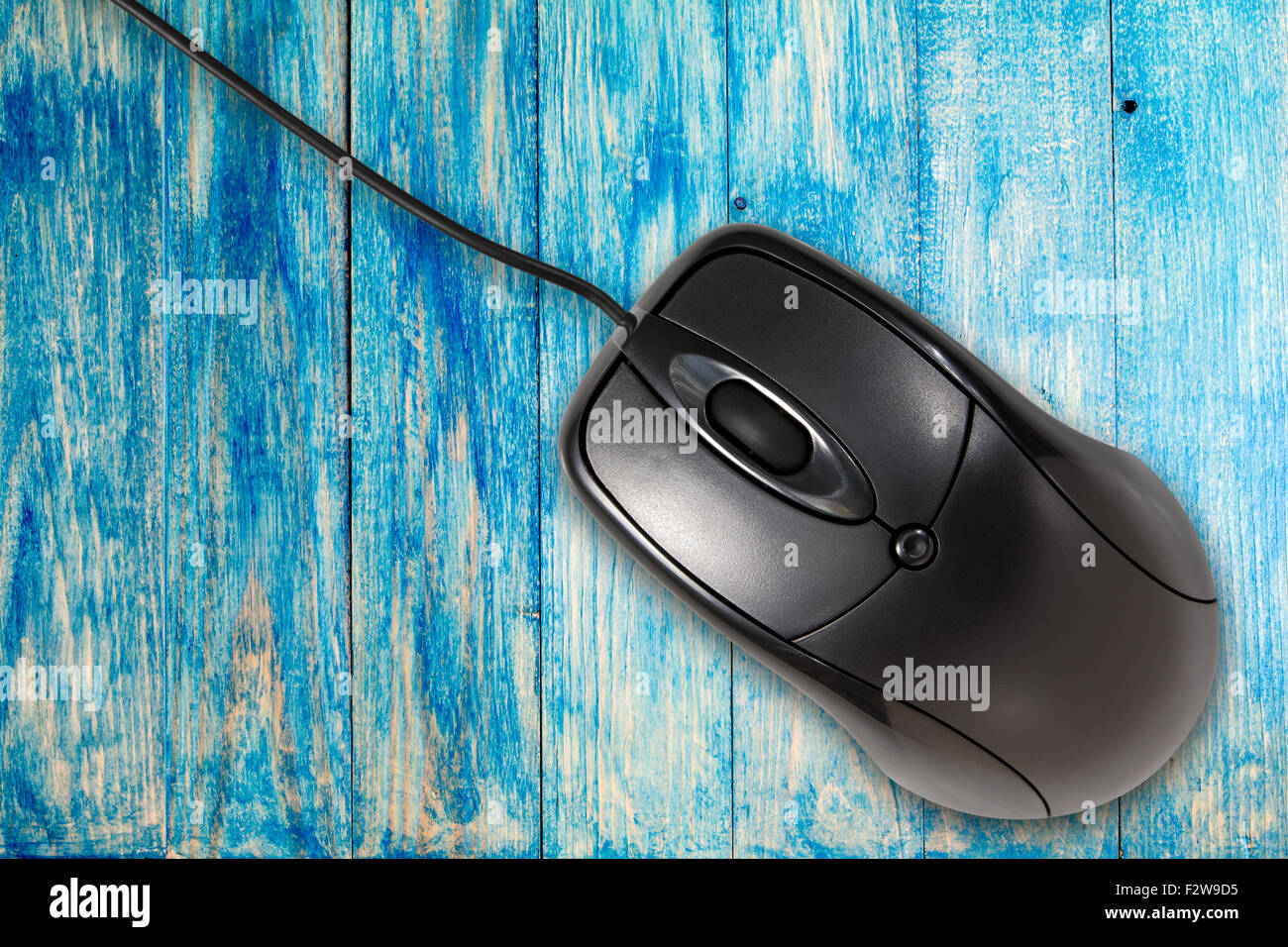 Black computer mouse on the blue wooden planks background Stock Photo