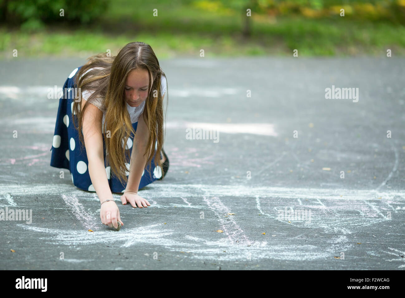 Teen girl drawing with chalk on the pavement Stock Photo Alamy
