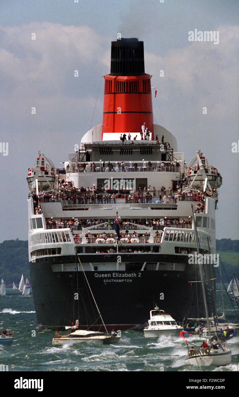 AJAXNETPHOTO - JUNE, 1994. - SPITHEAD, ENGLAND. - D-DAY ANNIVERSARY ROYAL FLEET REVIEW - CUNARD LINER QE2 PACKED WITH SIGHTSEERS SURROUNDED BY SMALL BOATS WAITING FOR HMRY BRITANNIA TO PASS.  PHOTO:JONATHAN EASTLAND/AJAX.  REF:1708 72. Stock Photo