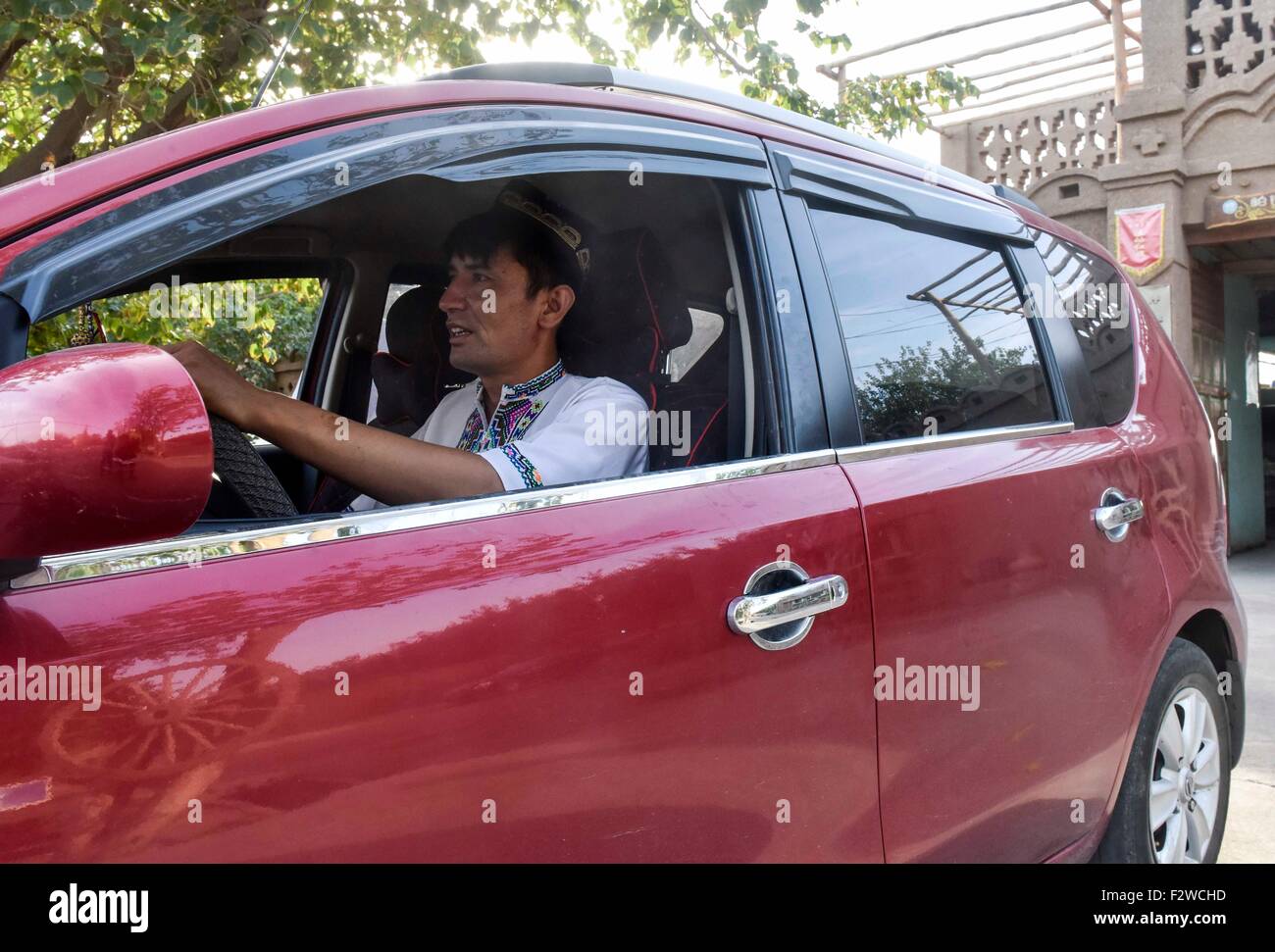(150924) -- TURPAN, Sept. 24, 2015 (Xinhua) -- Pataer Keyimu drives his car in the Grape Valley of Turpan, northwest China's Xinjiang Uygur Autonomous Region, Sept. 6, 2015. Compared with life of his grandfather, Pataer leads a new way of life by not only growing and selling grapes, but also tourism and other business thanks to the internet. In 2010, Pataer started a family stay business and sold local products, such as dried grapes, to attract tourists. This year, he estimates that the yearly earnings would reach 150,000 RMB yuan (about 23,505 US dollars). As the 3G service provided by China  Stock Photo