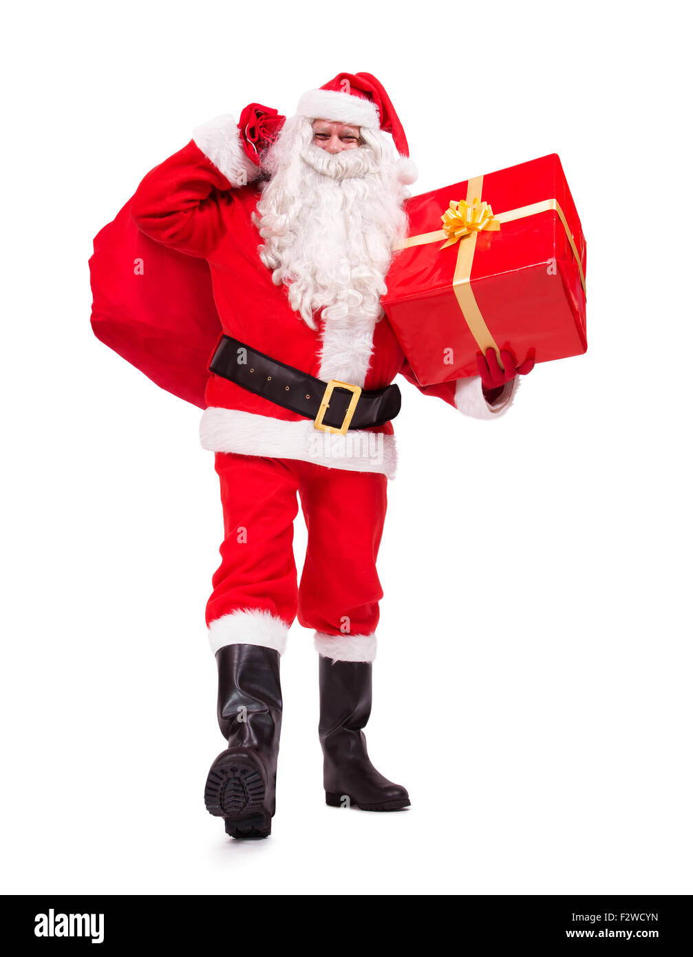 walking Santa Claus carries Christmas gifts isolated on white background Stock Photo