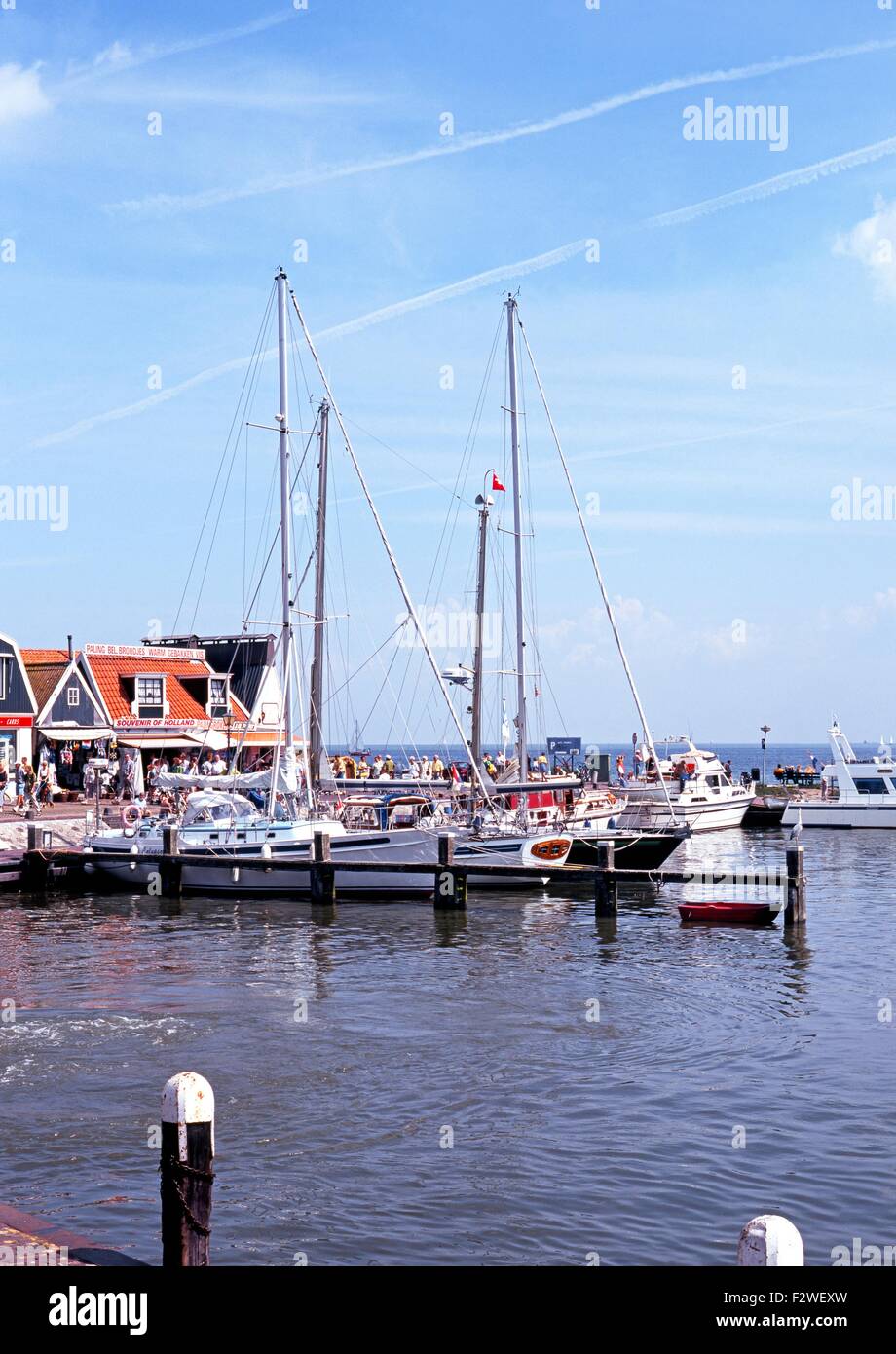 Yachts moored in the harbour with pavement cafes to the rear, Volendam, Holland, Netherlands, Europe. Stock Photo