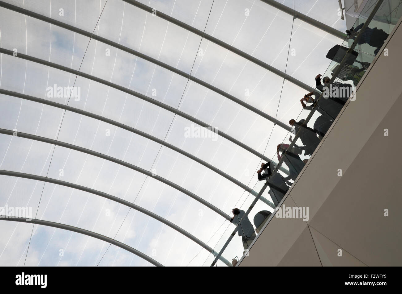 Visitors to Birmingham's Grand Central shopping centre look over the atrium balcony above the newly renovated New Street station. Stock Photo