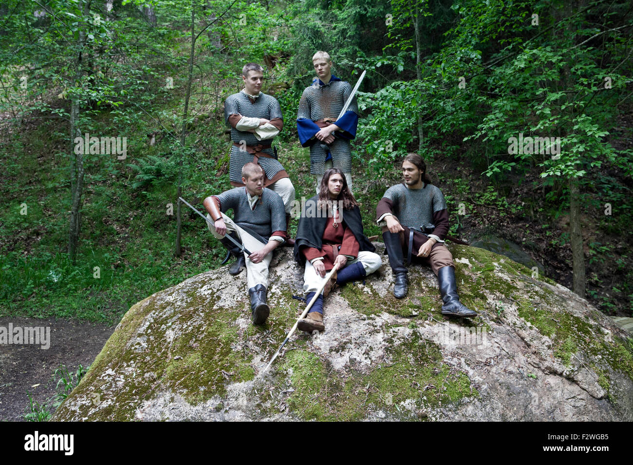 Members of the Folklore and Ancient Fight group Vilkaci sitting on rock Stock Photo