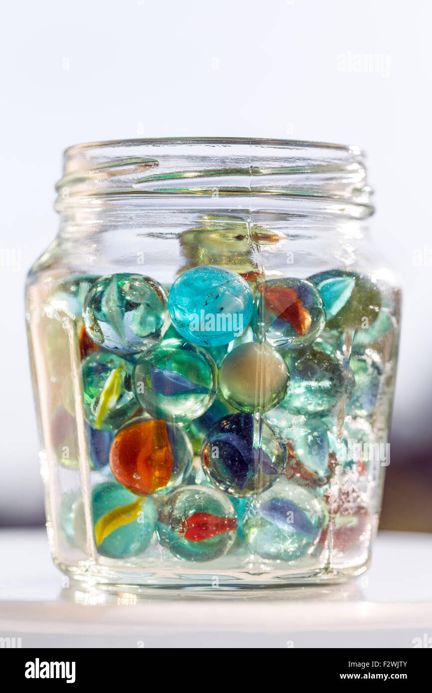A glass jar of marbles, UK Stock Photo