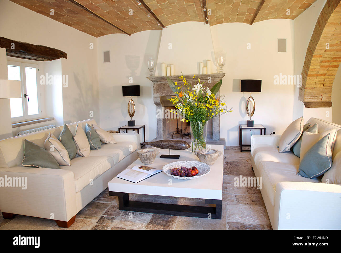Modern white sofas and coffee table with arrangement of summer flowers