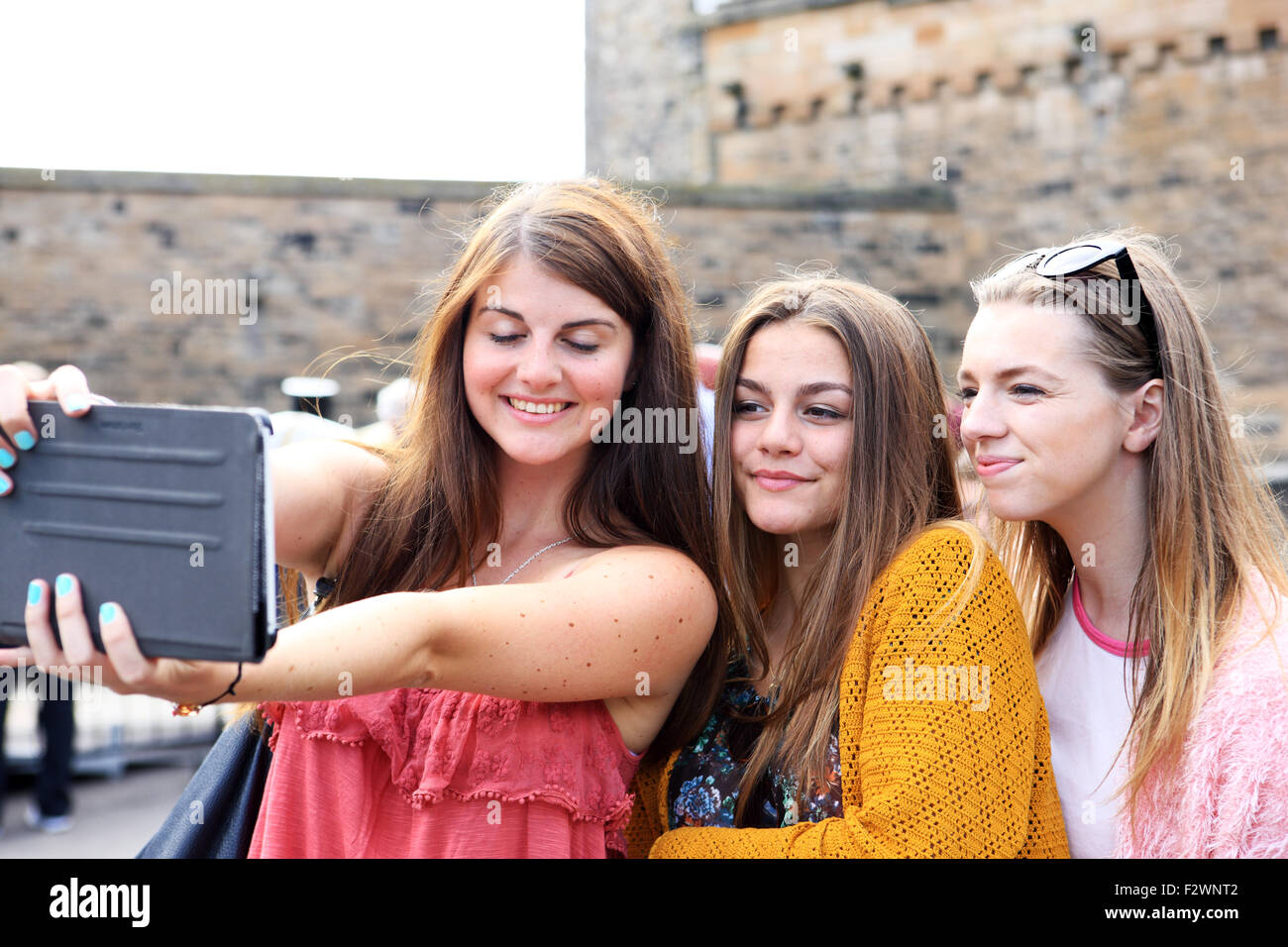 Three pretty young girls taking a selfie at Edinburgh Castle Stock Photo