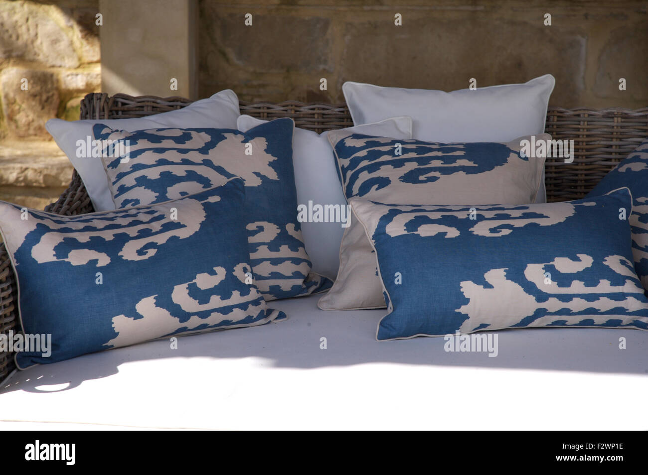 Blue and white cusions on a wicker sofas Stock Photo