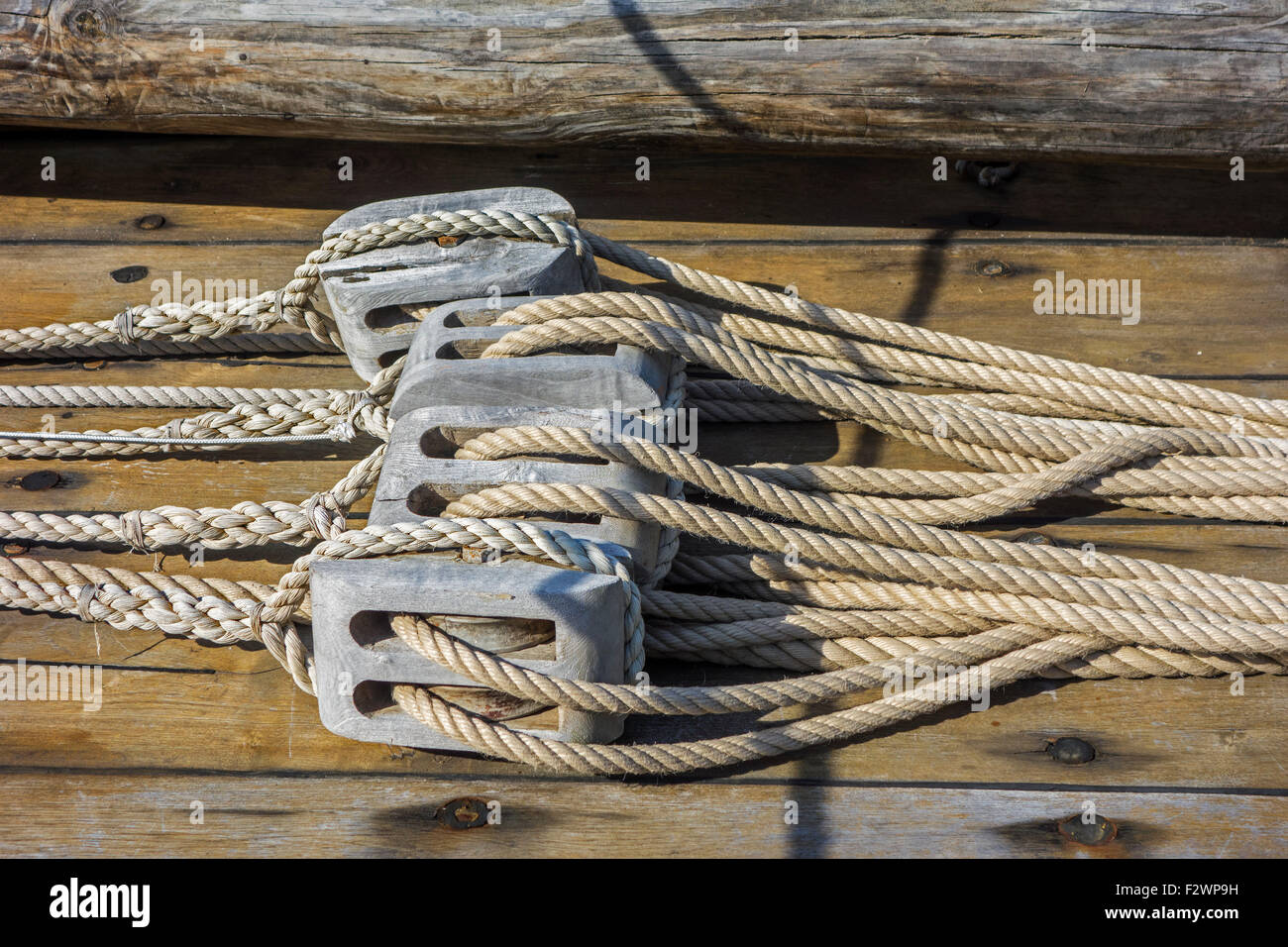 Ropes in wooden pulleys / blocks on deck of sailing boat / yacht Stock Photo