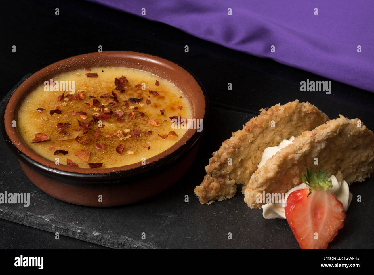Creme brulee dessert dish served with chilli flakes. Stock Photo