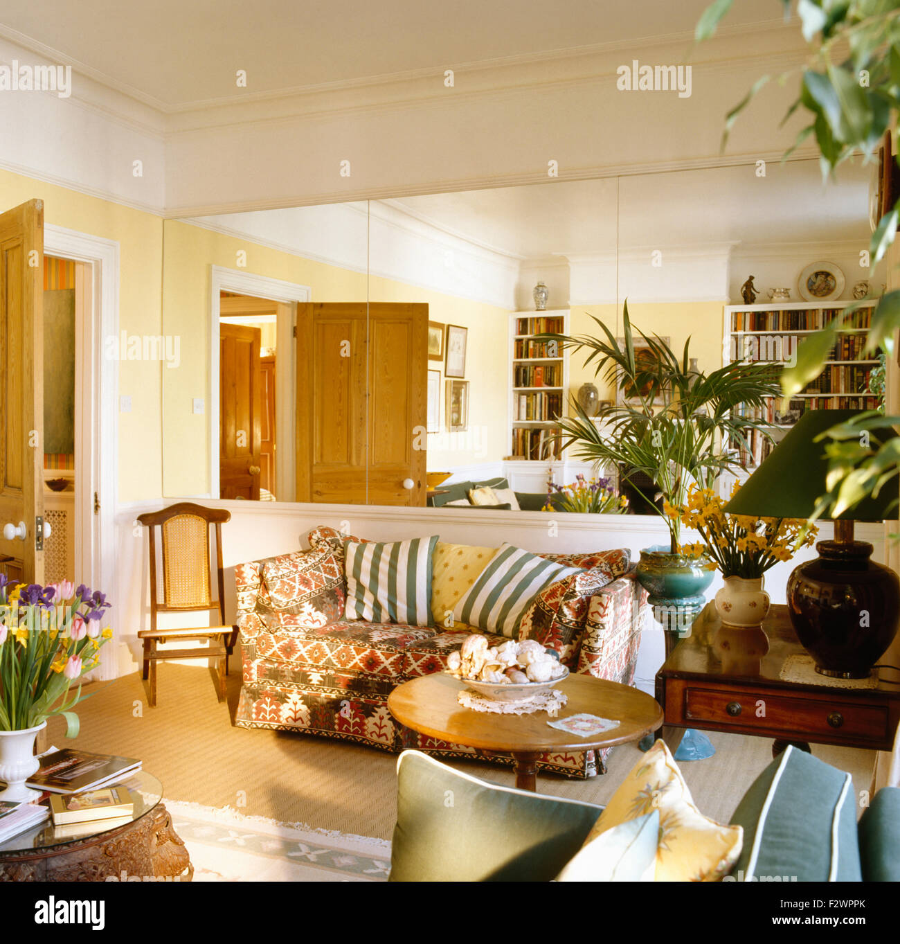 Mirrored wall above sofa in nineties living room Stock Photo - Alamy