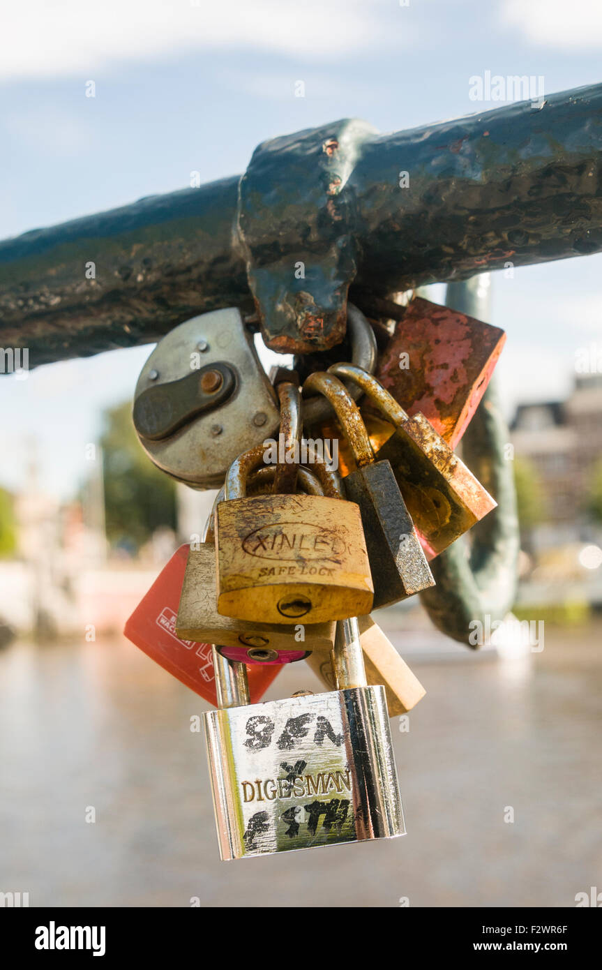Rusty padlocks on a bridge in Amsterdam, placed there by lovers to show their love. Stock Photo