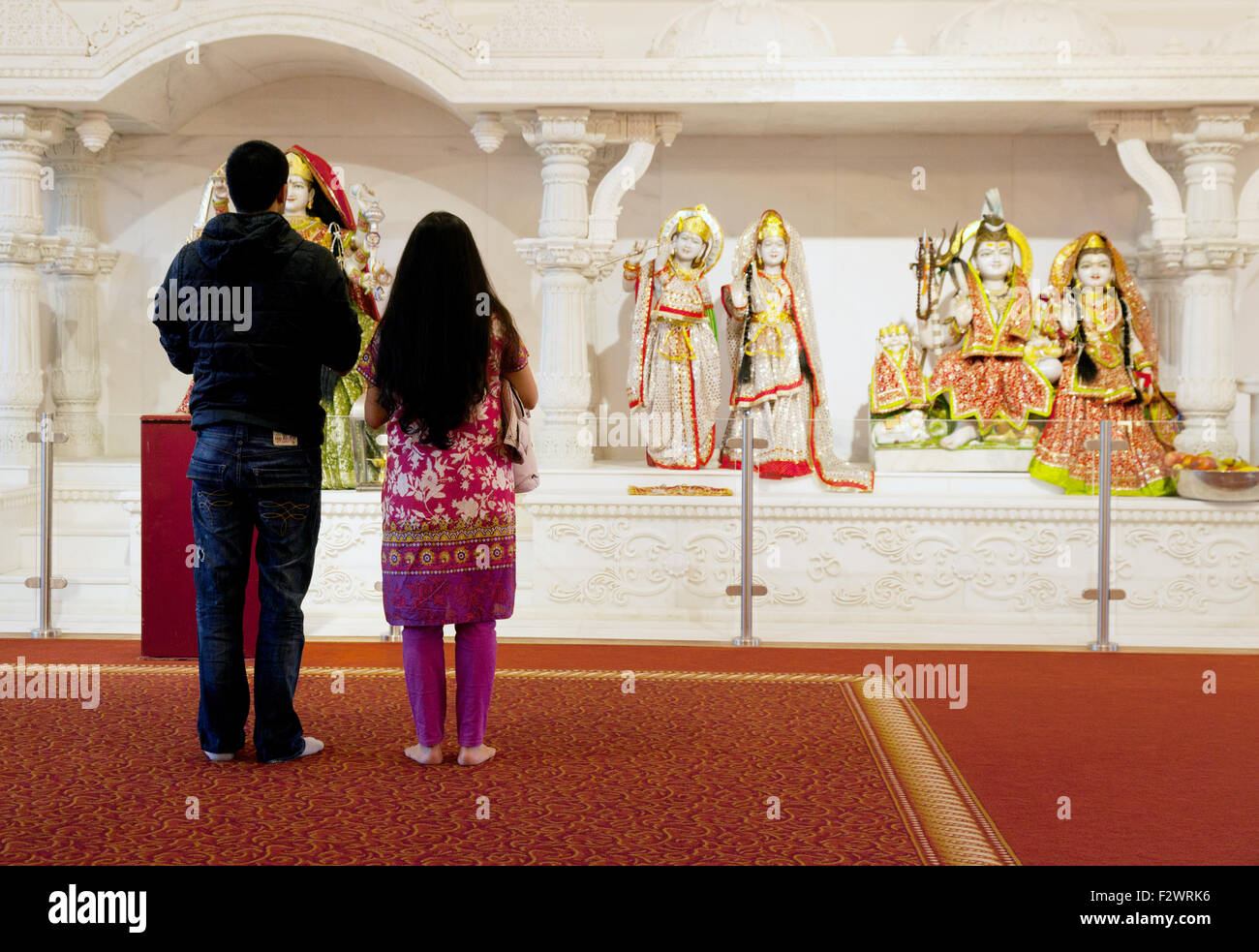 A Hindu couple looking at Hindu Gods, the Reading Hindu temple, Reading, Berkshire England UK, example of multicultural Britain Stock Photo