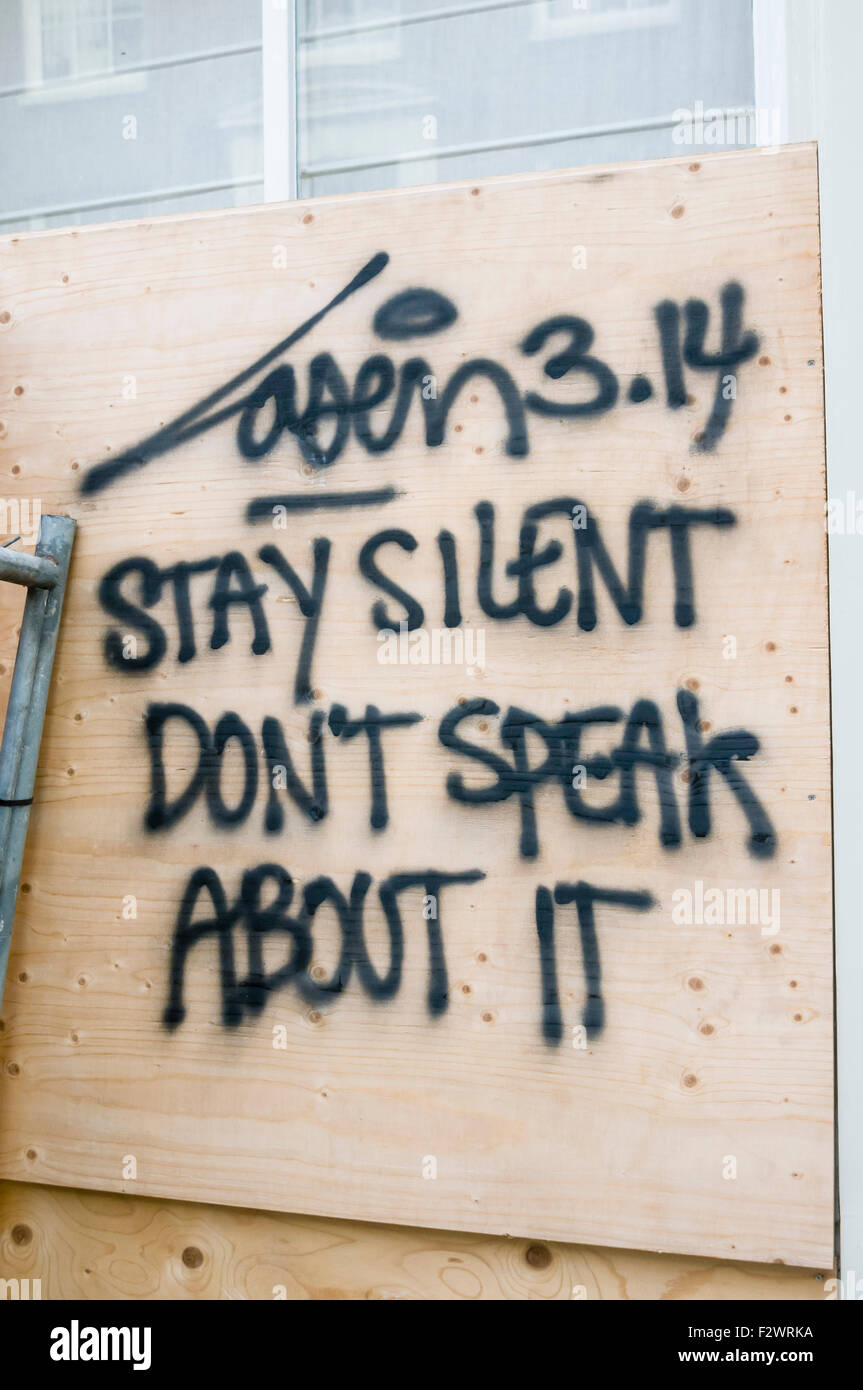 Graffiti on a wooden hoarding in Amsterdam  saying 'Stay silent. Don't speak about it' Stock Photo