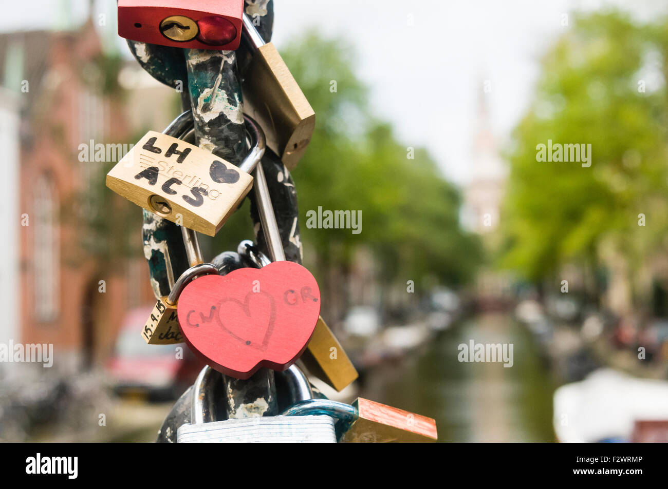 Padlocks attached to the chain of a bridge over a canal in Amsterdam, left by lovers to show their love. Stock Photo