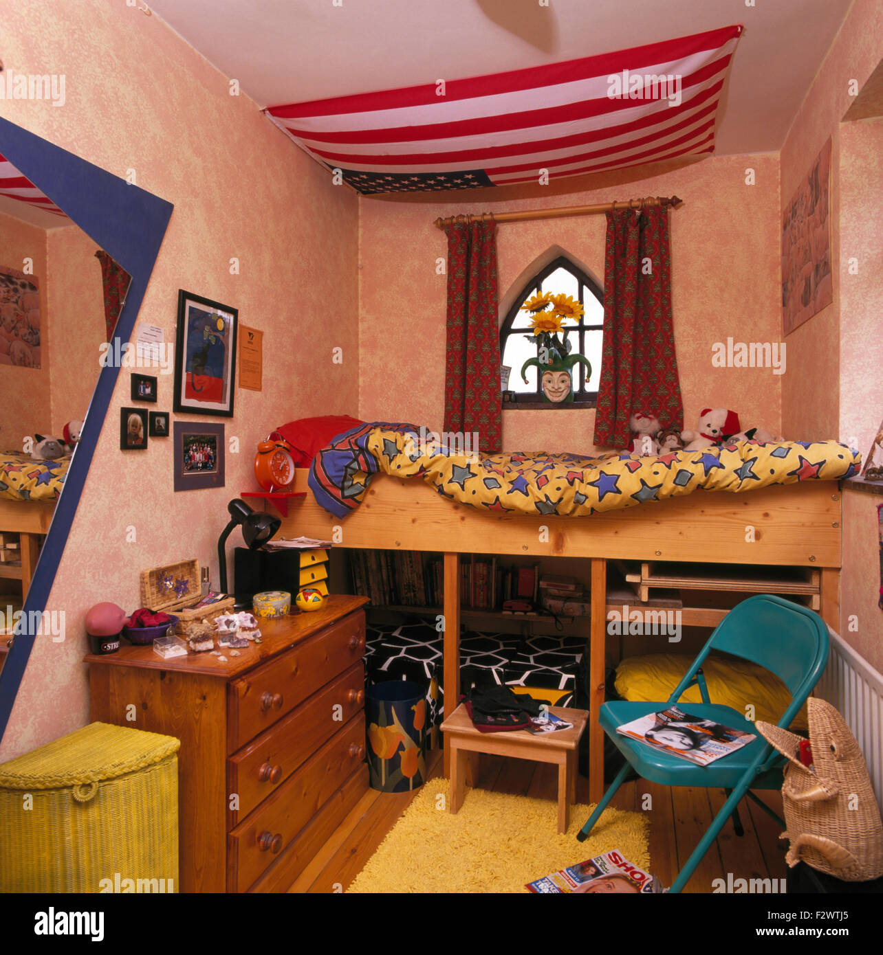 Red striped awning above simple bunk beds in child's nineties bedroomn Stock Photo