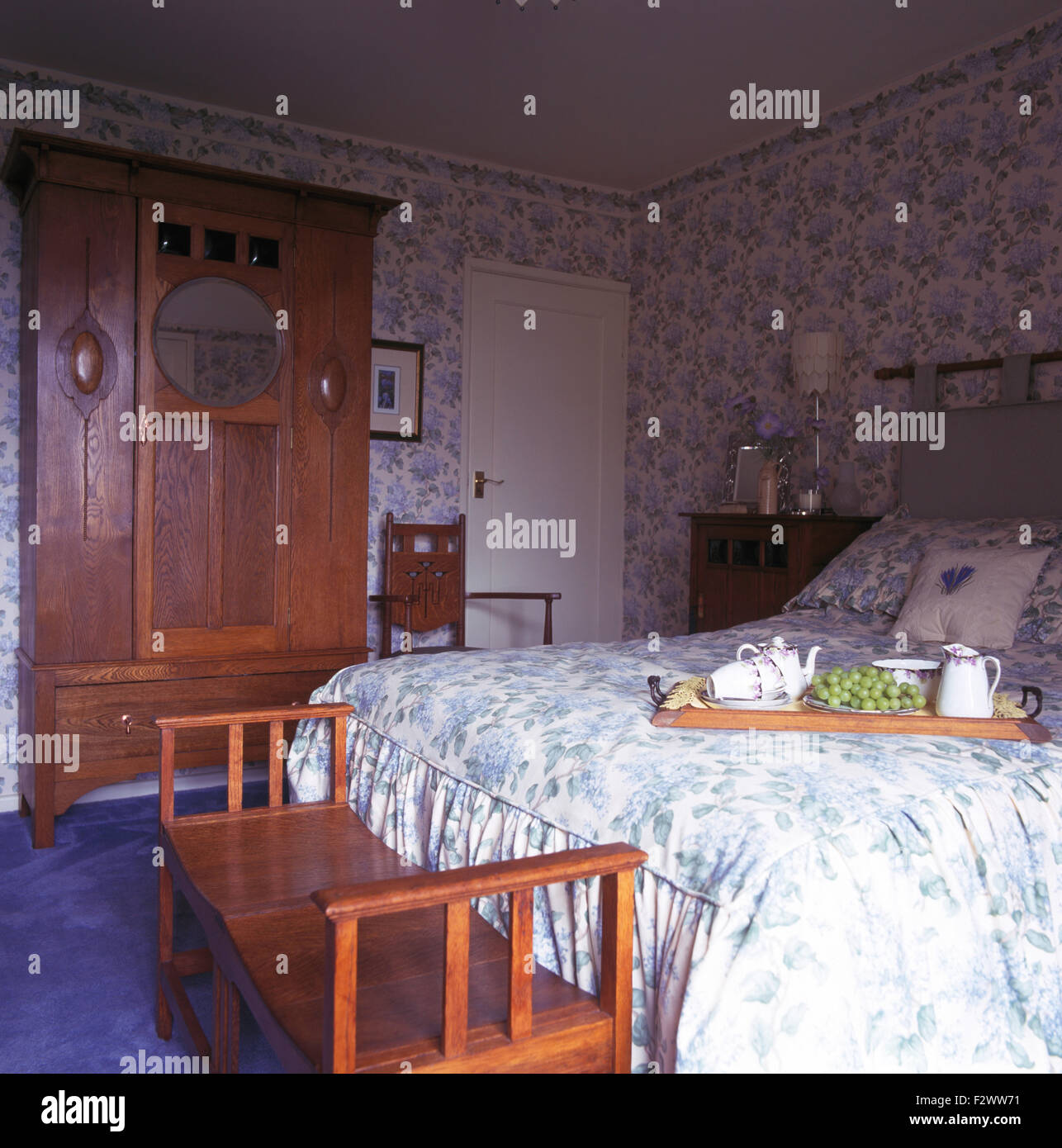 Art Nouveau wardrobe and stool in nineties bedroomn with breakfast tray on the bed Stock Photo