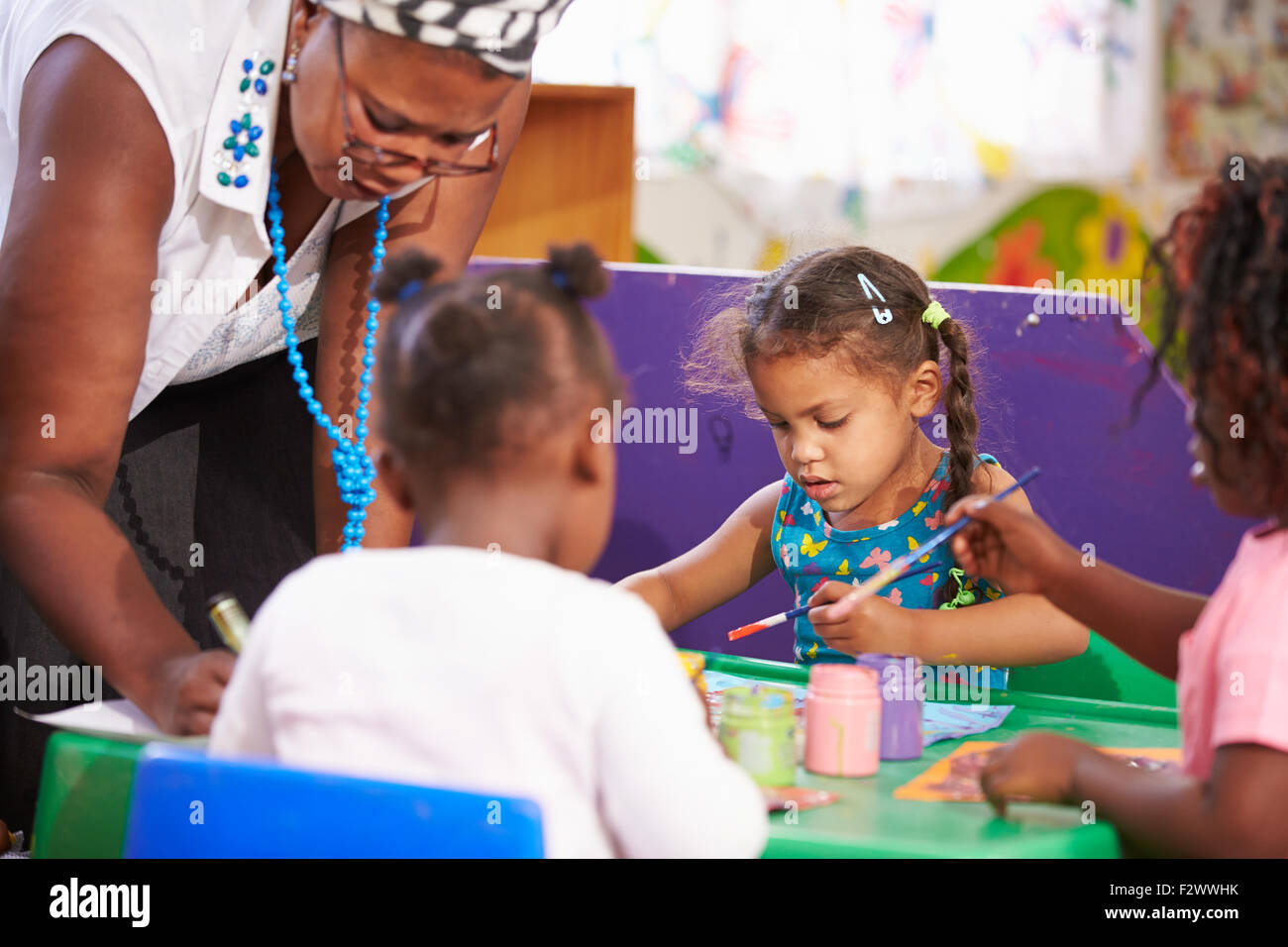 Teacher helping kids in a preschool class, close up Stock Photo