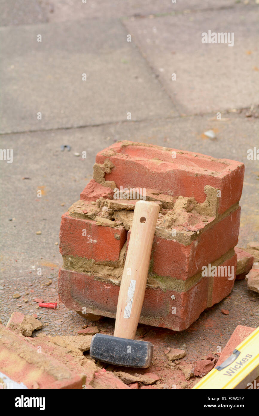 Lump hammer resting against broken brick wall Stock Photo Alamy