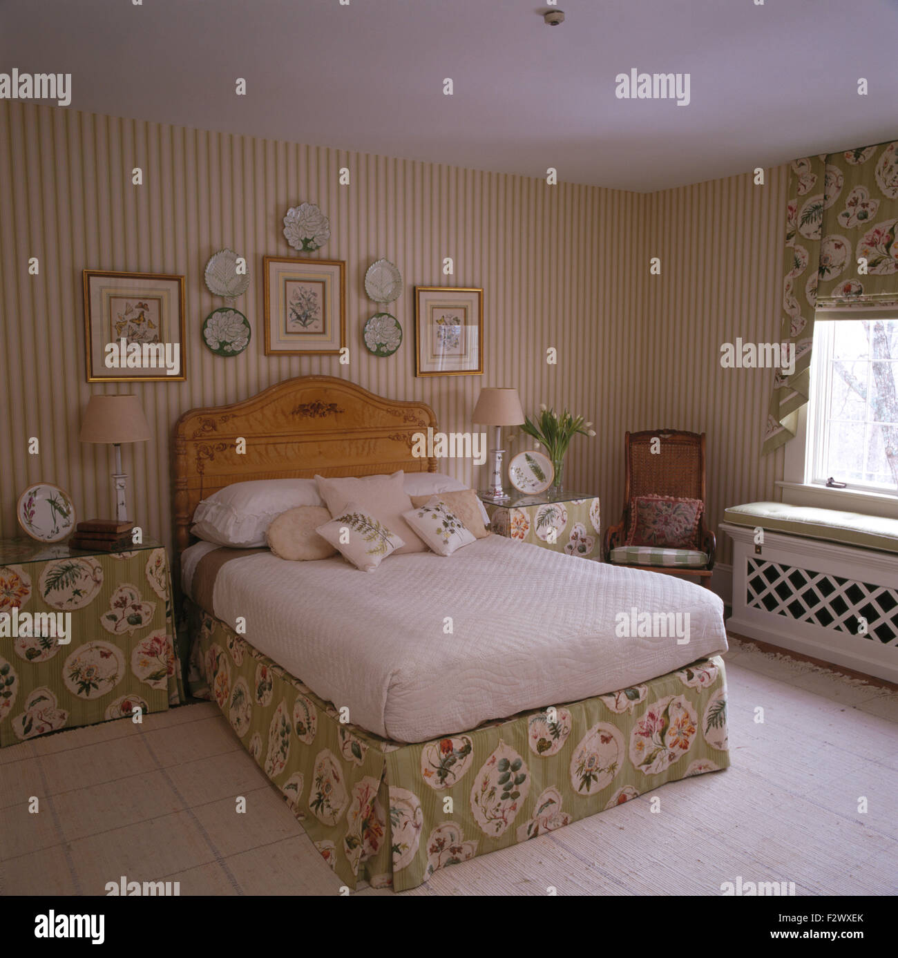 Striped wallpaper and bedside table with fitted green cloths in
