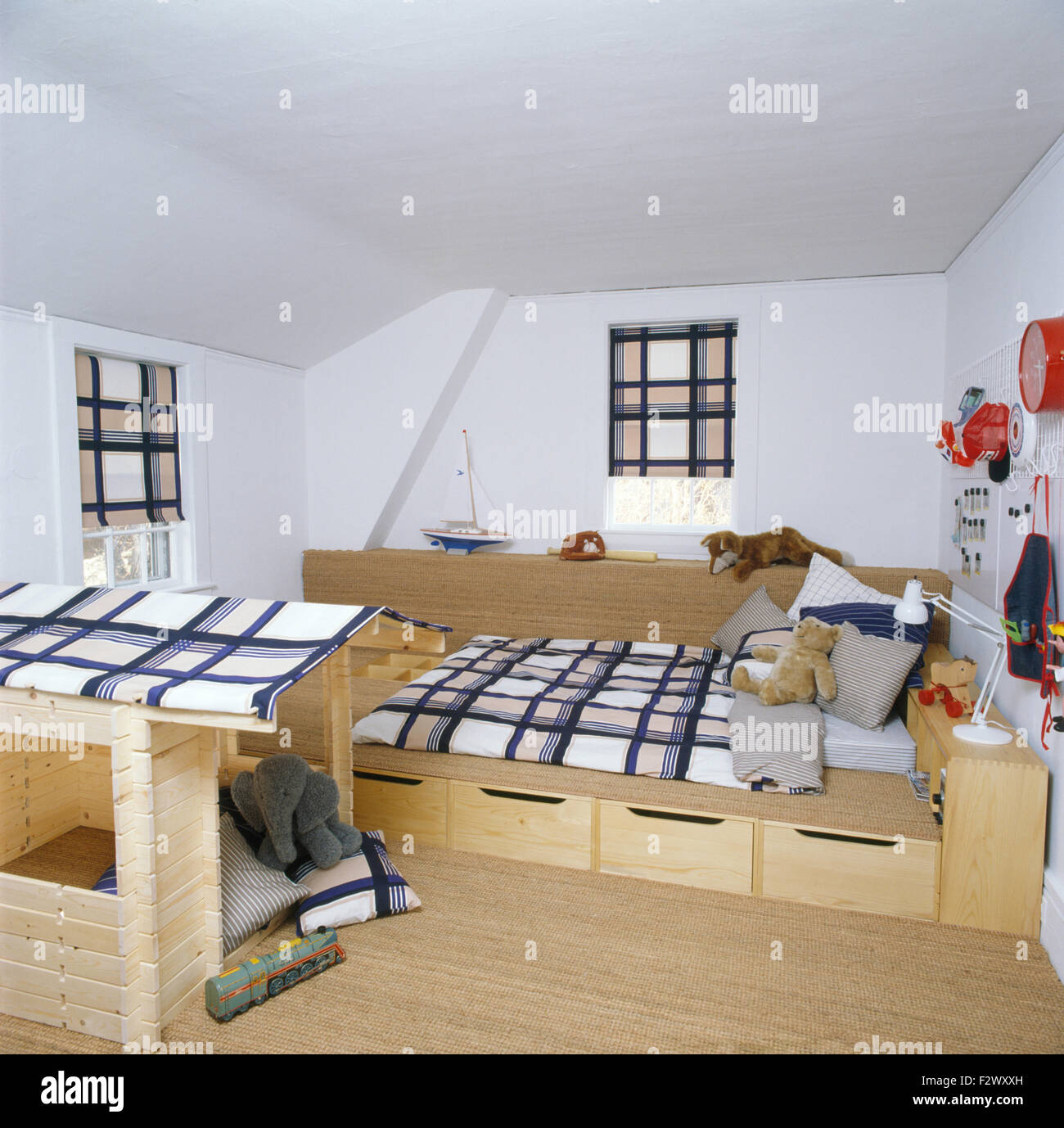 Under bed storage drawers below fitted bed with checked cover in