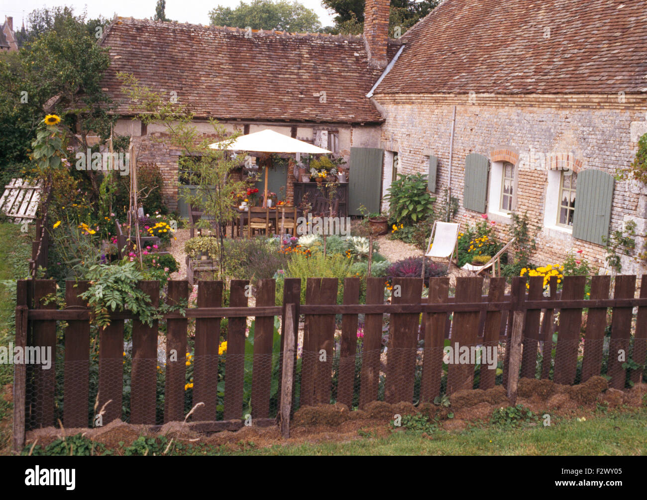 Wooden fence bordering courtyard garden of old French country house