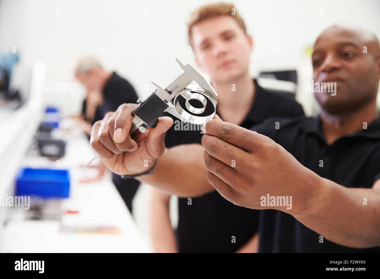 Engineer In Factory With Apprentice Checks Component Quality Stock Photo