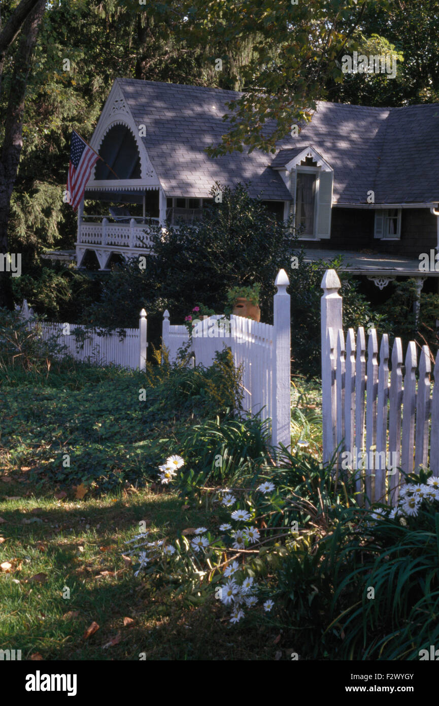 White picket fence in garden of clapboard house in the USA Stock Photo
