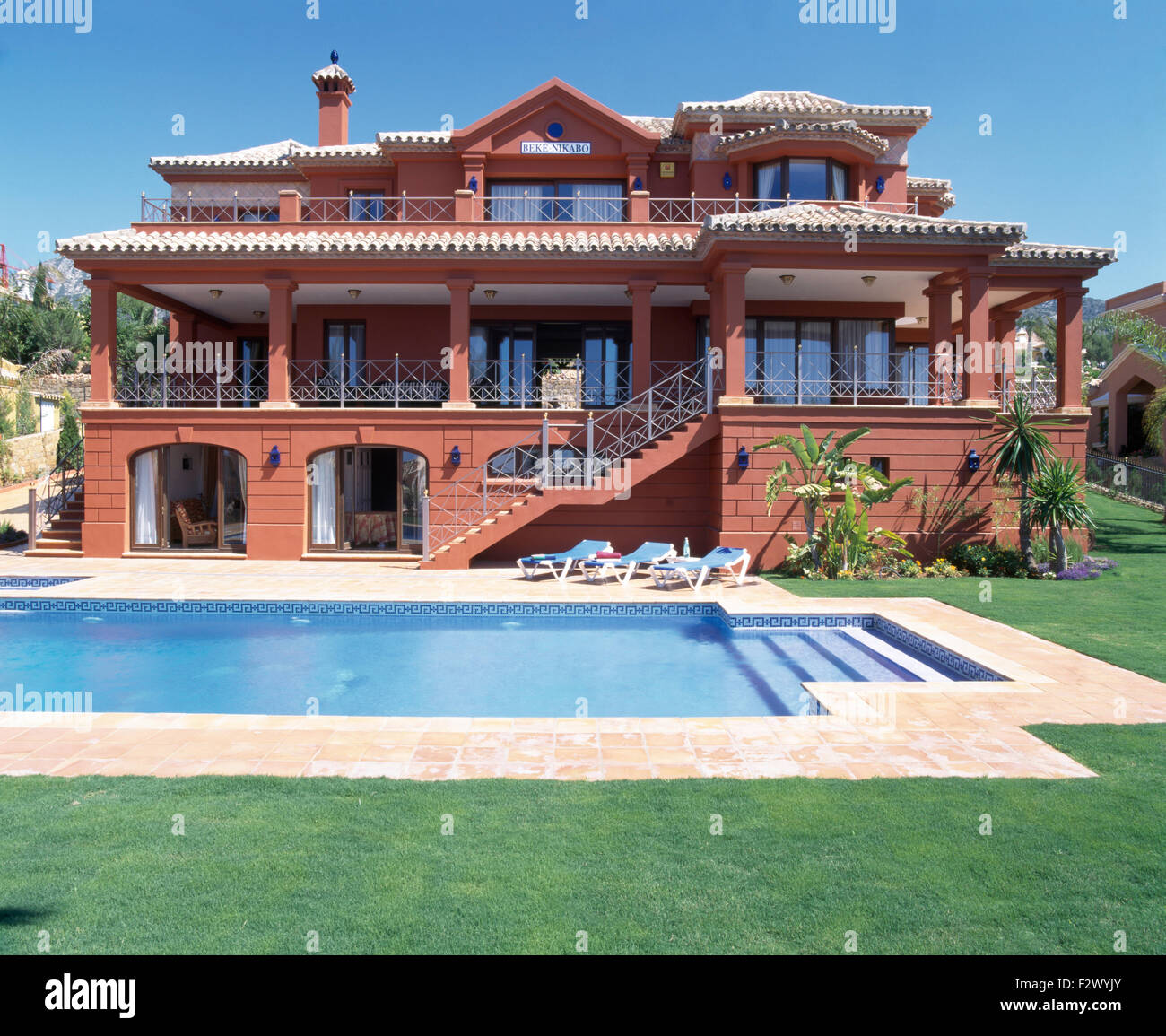 Exterior of large terracotta coloured Spanish villa with a turquoise ...