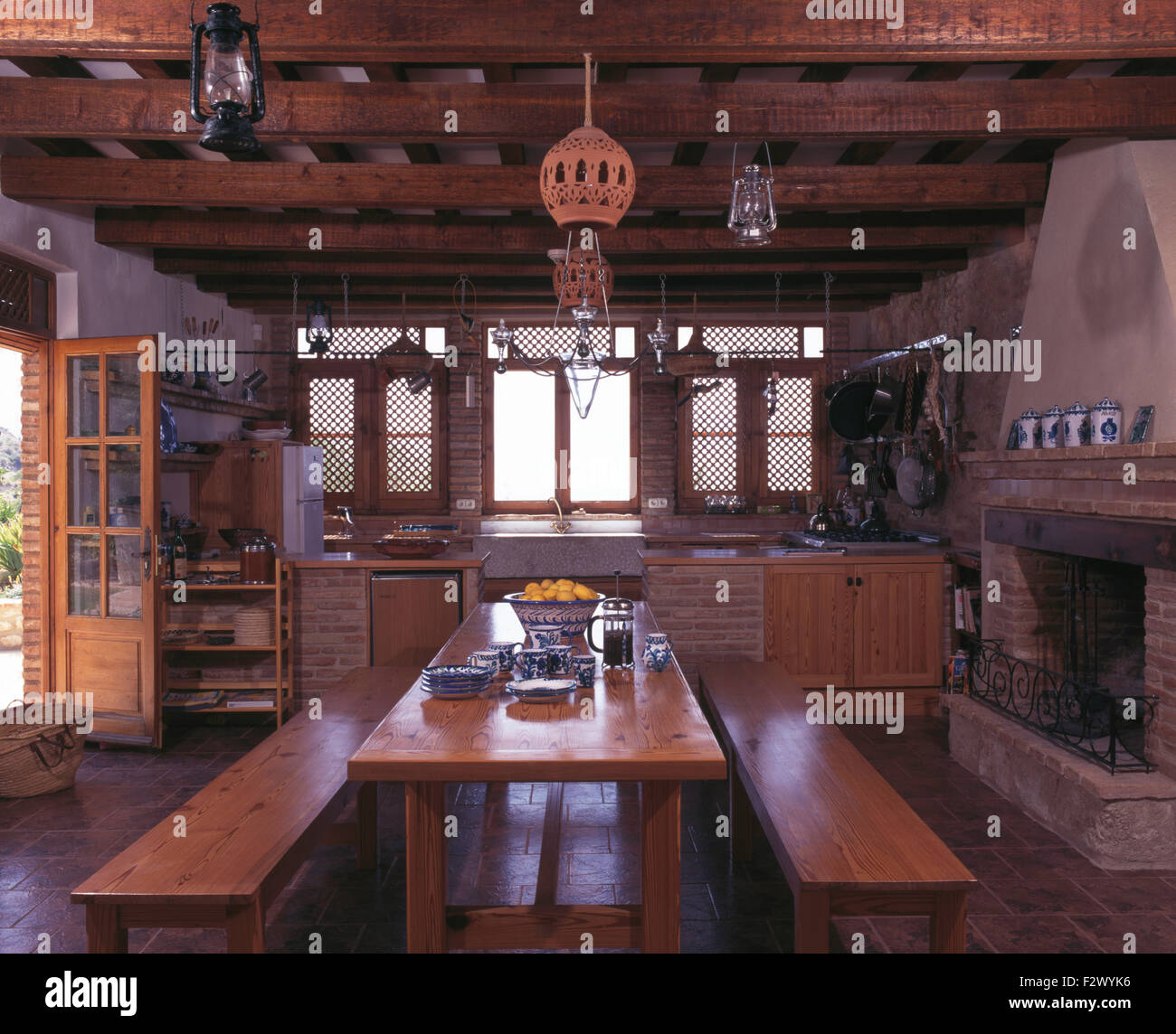 Wooden Benches And Table In Spanish Country Kitchen With