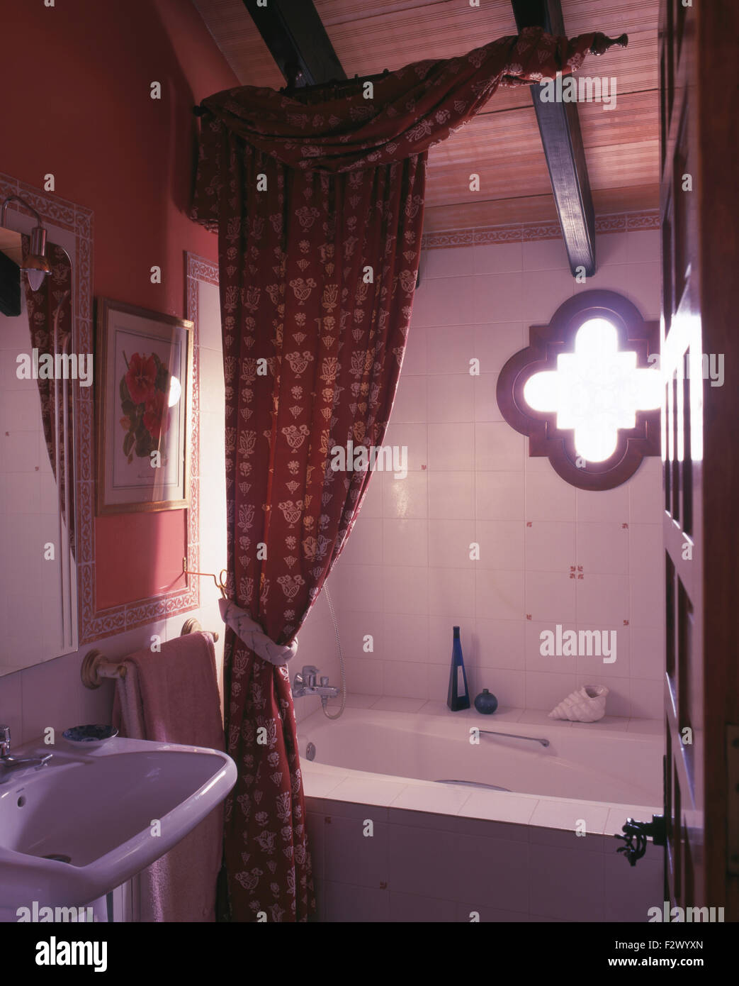 Patterned curtain on bath in Spanish country bathroom Stock Photo Alamy
