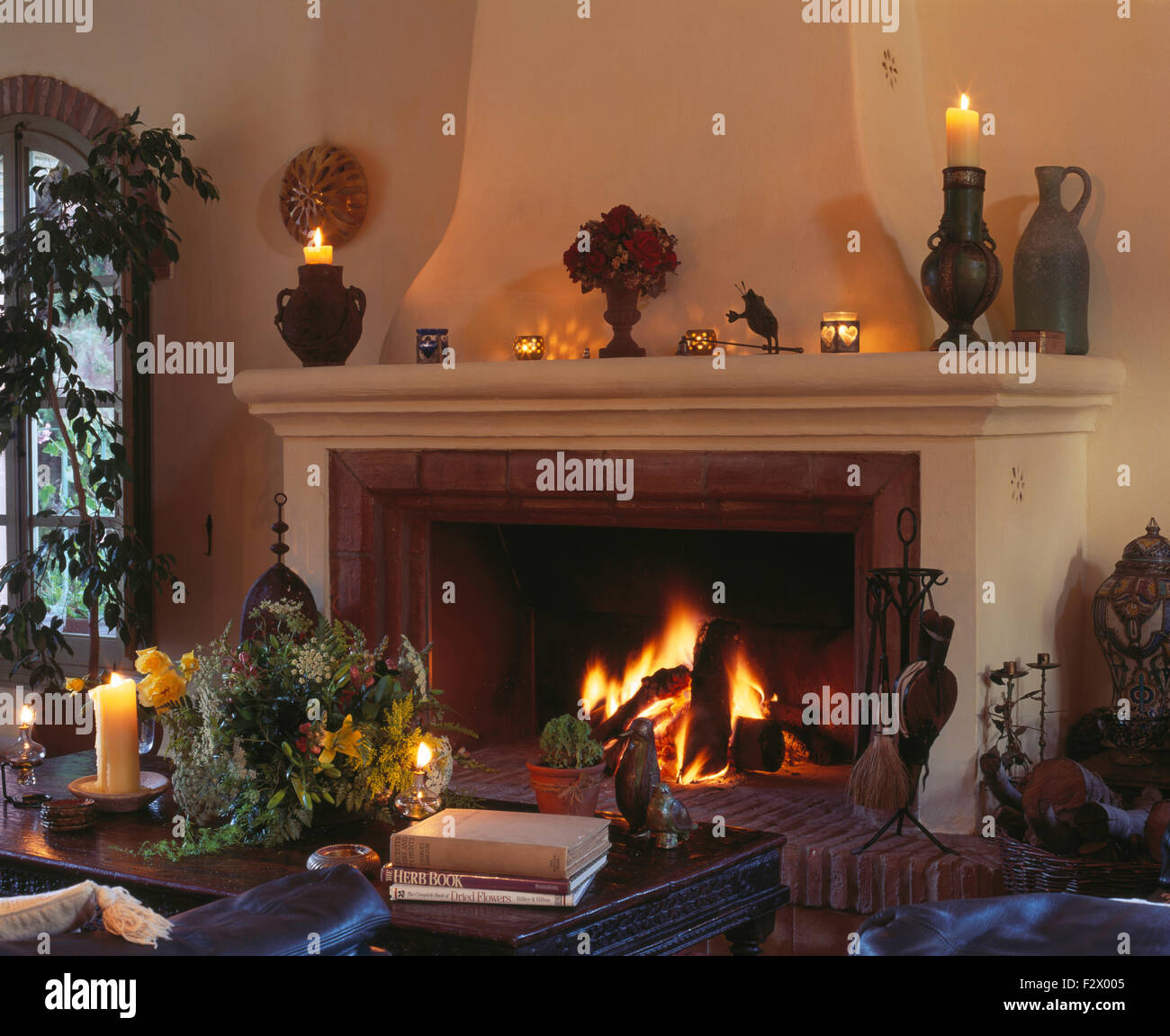 Lighted Fire In Large Fireplace In Cosy Spanish Living Room With