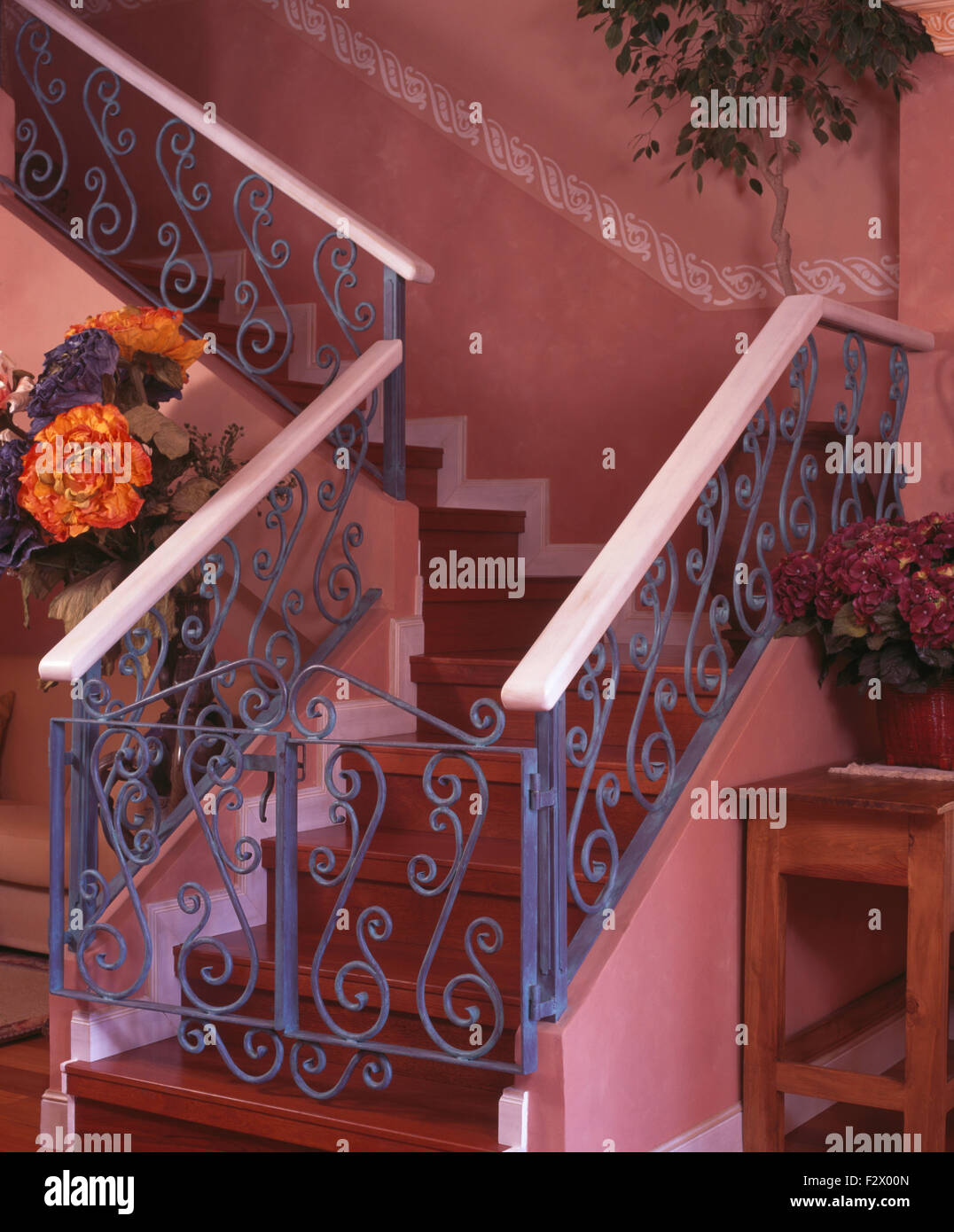 Blue wrought iron banisters and gate on wooden staircase in Spanish hall Stock Photo