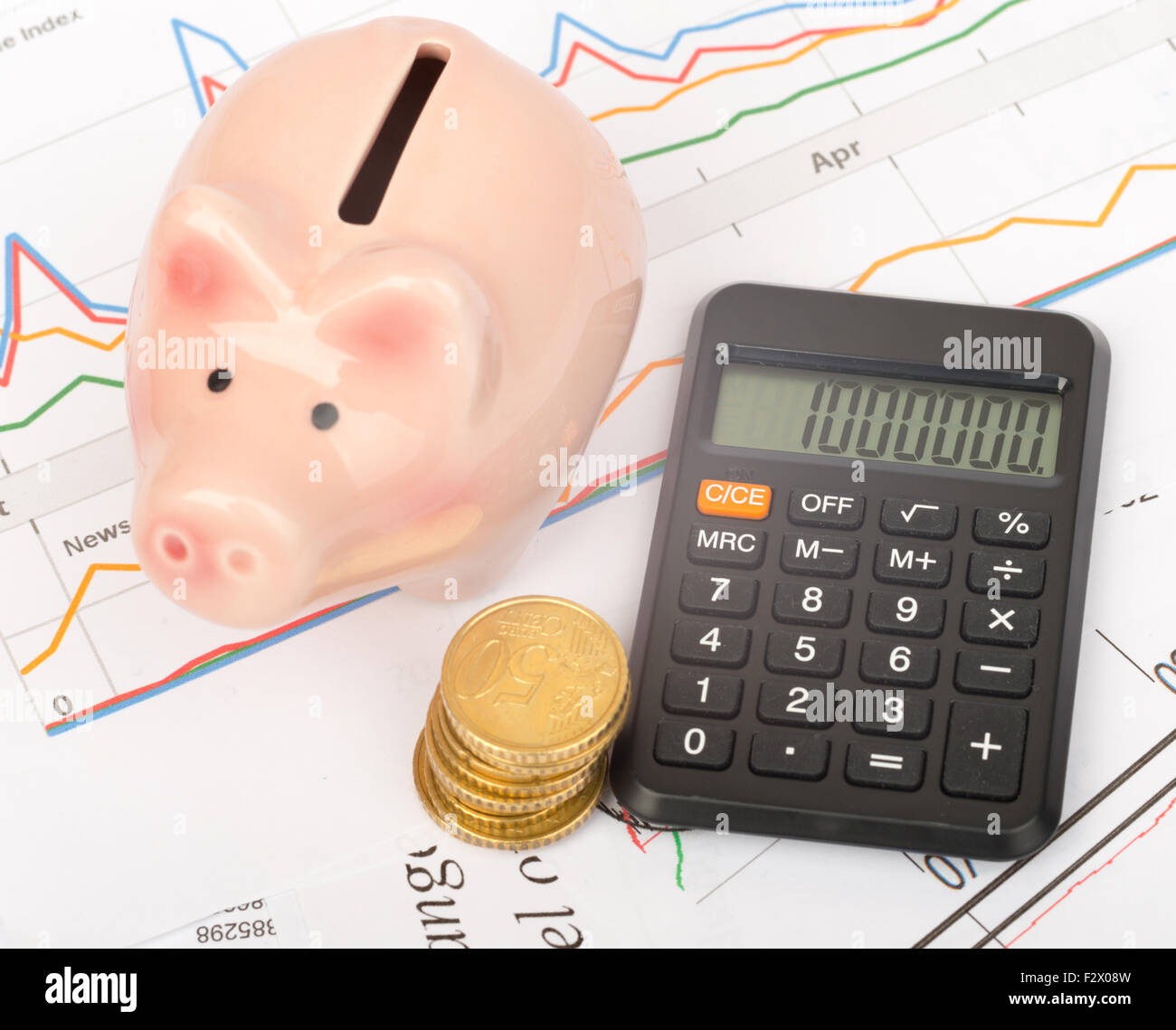 Piggy bank with coins and calculator Stock Photo - Alamy