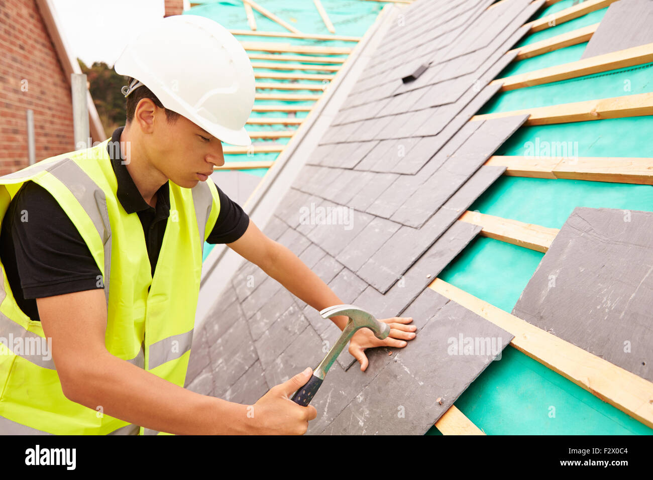 Construction Worker On Building Site Laying Slate Tiles Stock Photo - Alamy