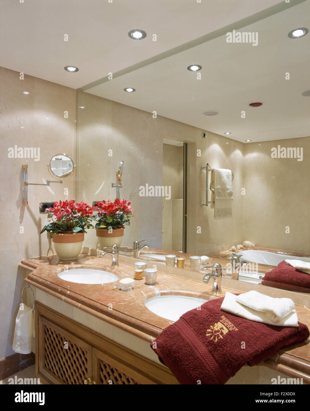 Mirrored wall above vanity unit with under-set washbasins in modern Spanish bathroom Stock Photo