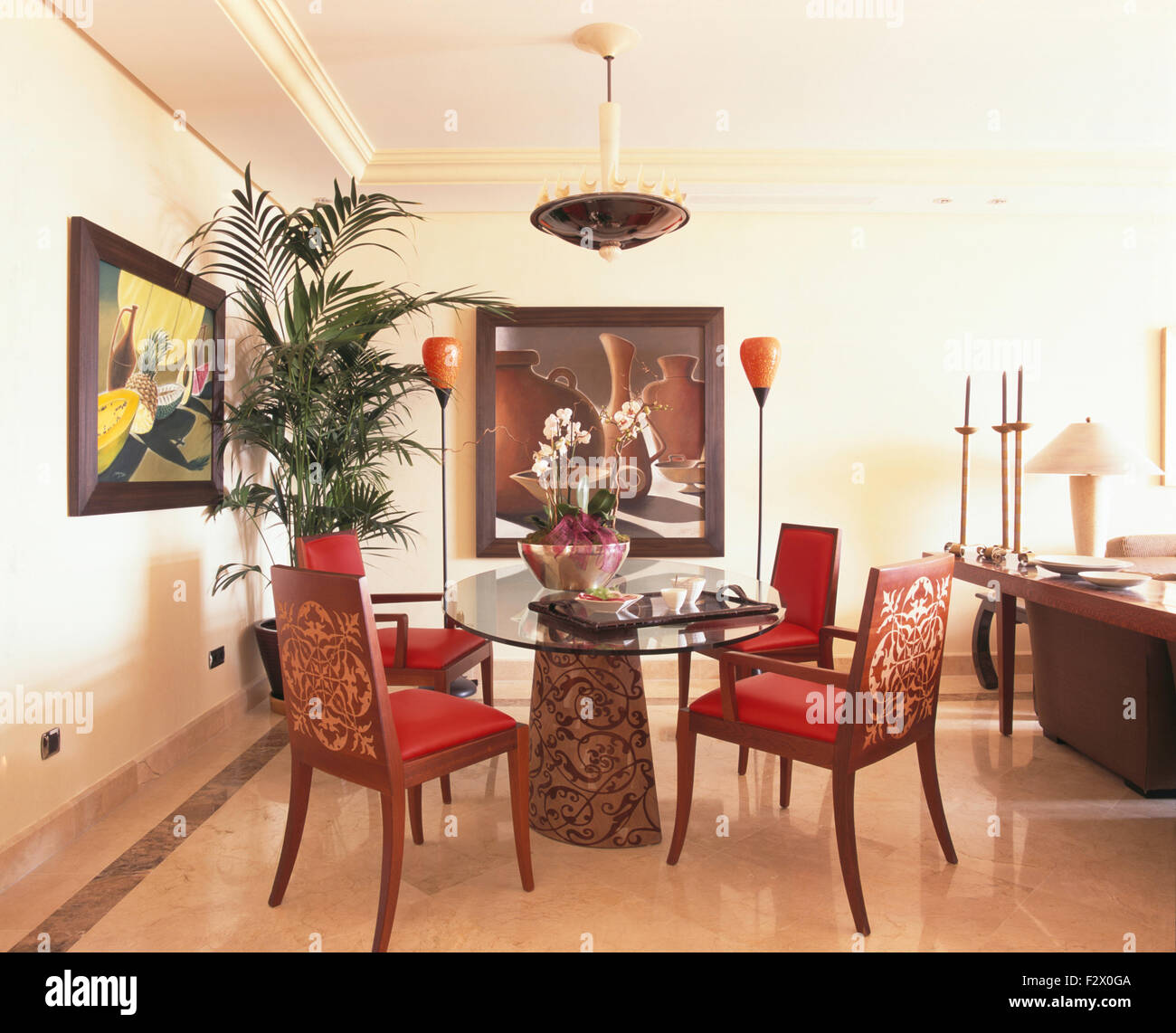 Upholstered chairs at unusual glass topped table in modern Spanish