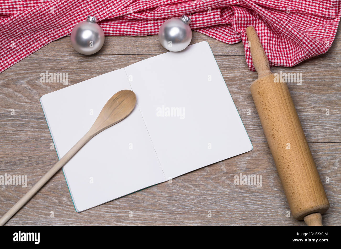 Image shows an open booklet with rolling pin and christmas balls on a table Stock Photo