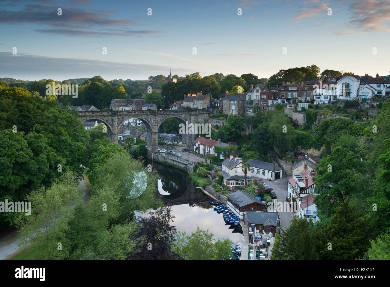 Blue sky over Knaresborough, England, UK - scenic sunny summer view of viaduct bridge over River Nidd, reflections, riverside boats & hillside houses. Stock Photo