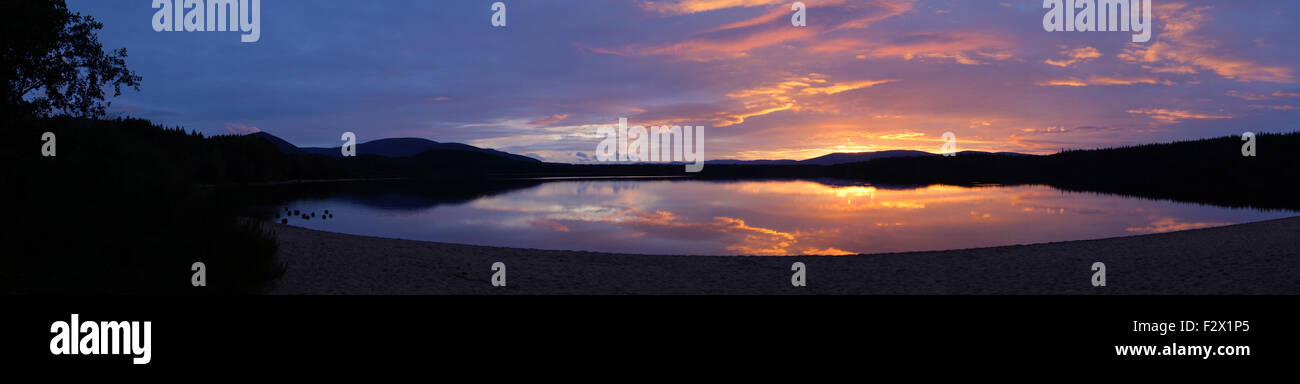 Colorful sunset with mountain reflection panoramic at Loch Morlich, Aviemore, Scotland Stock Photo