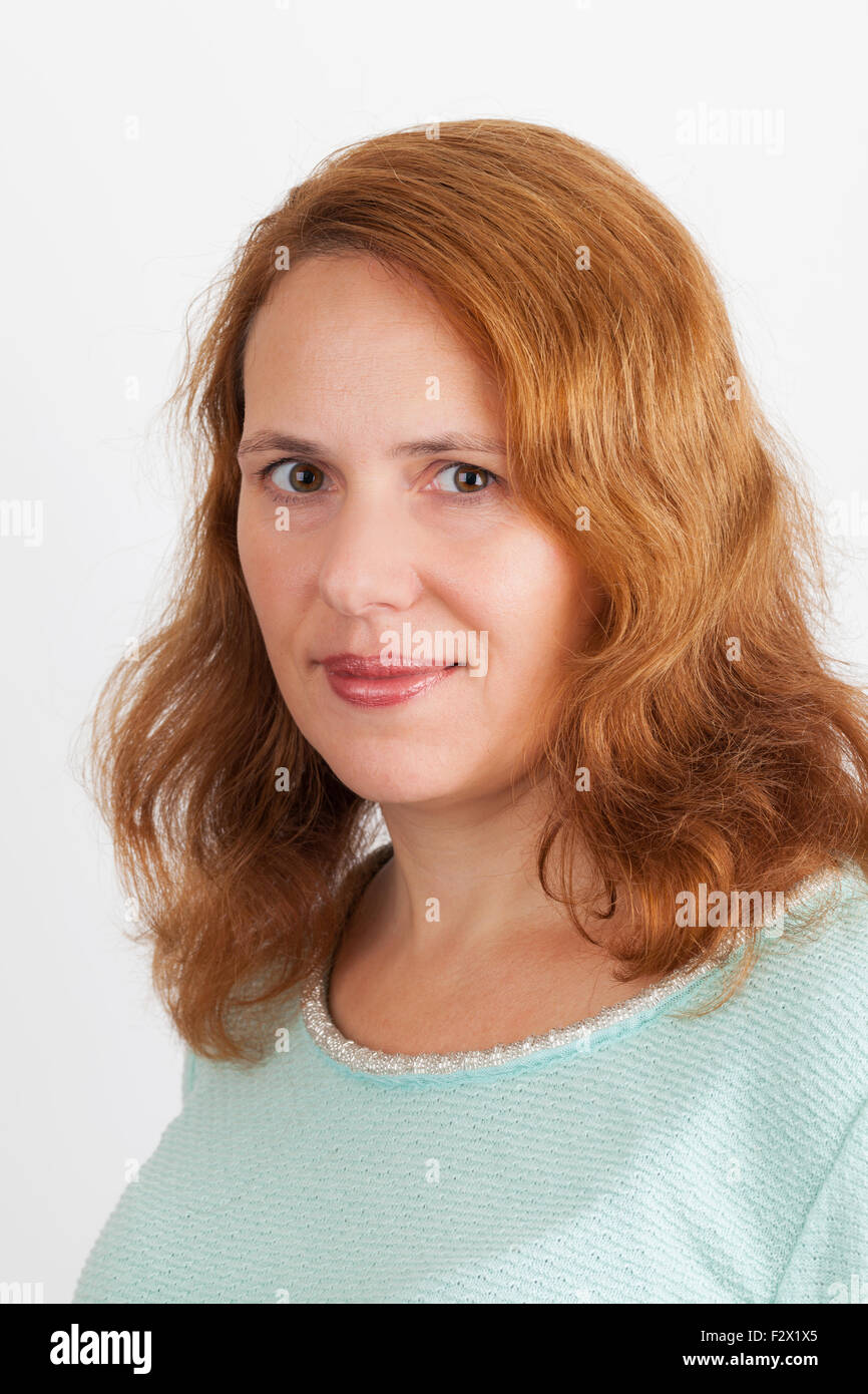 Young smiling Caucasian woman, closeup studio portrait on light gray background Stock Photo