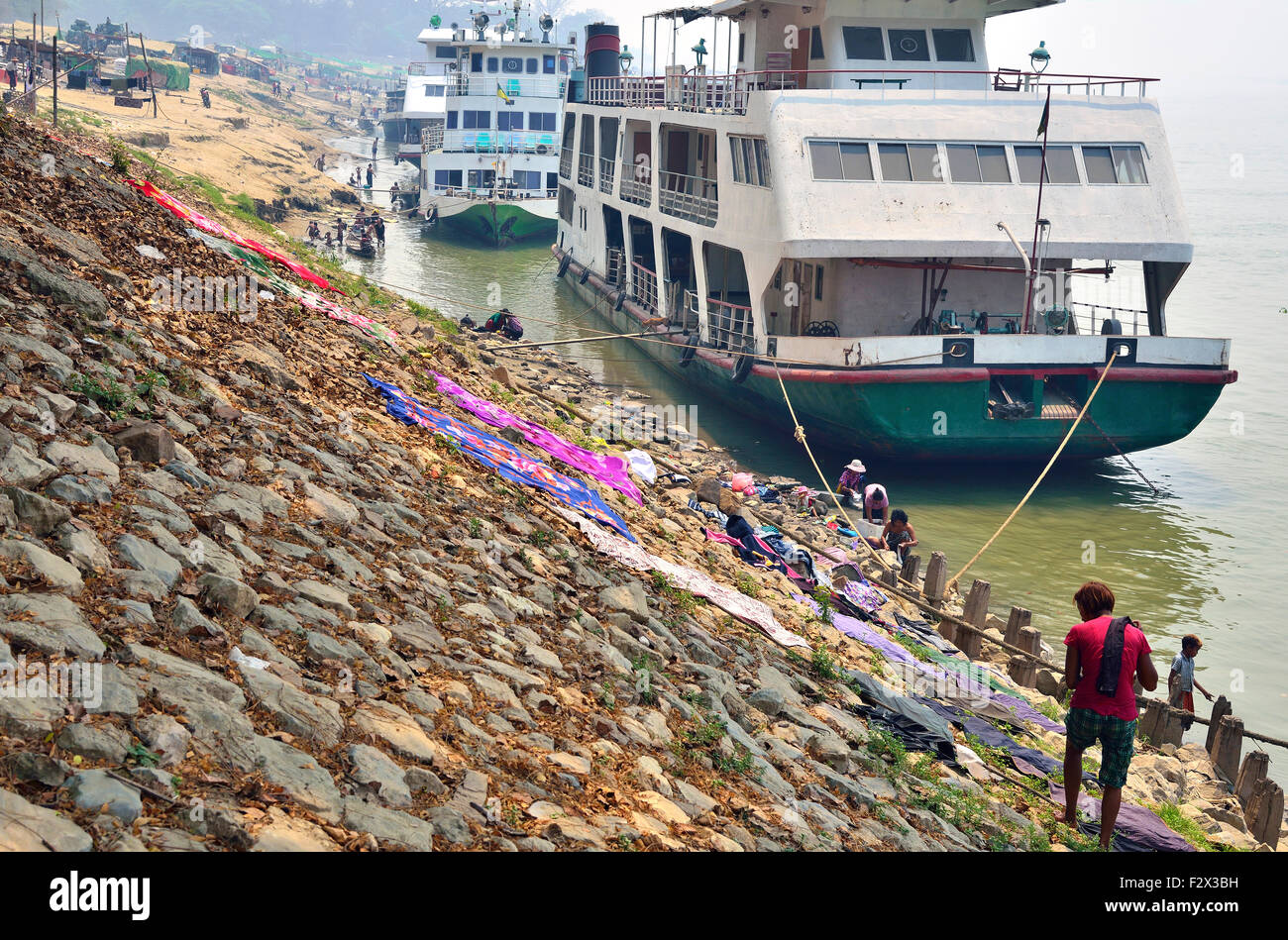 Boats moored and laundry drying on the banks of the Irrawaddy/ Ayeyarwady River, at Mandalay, Myanmar (Burma) Stock Photo