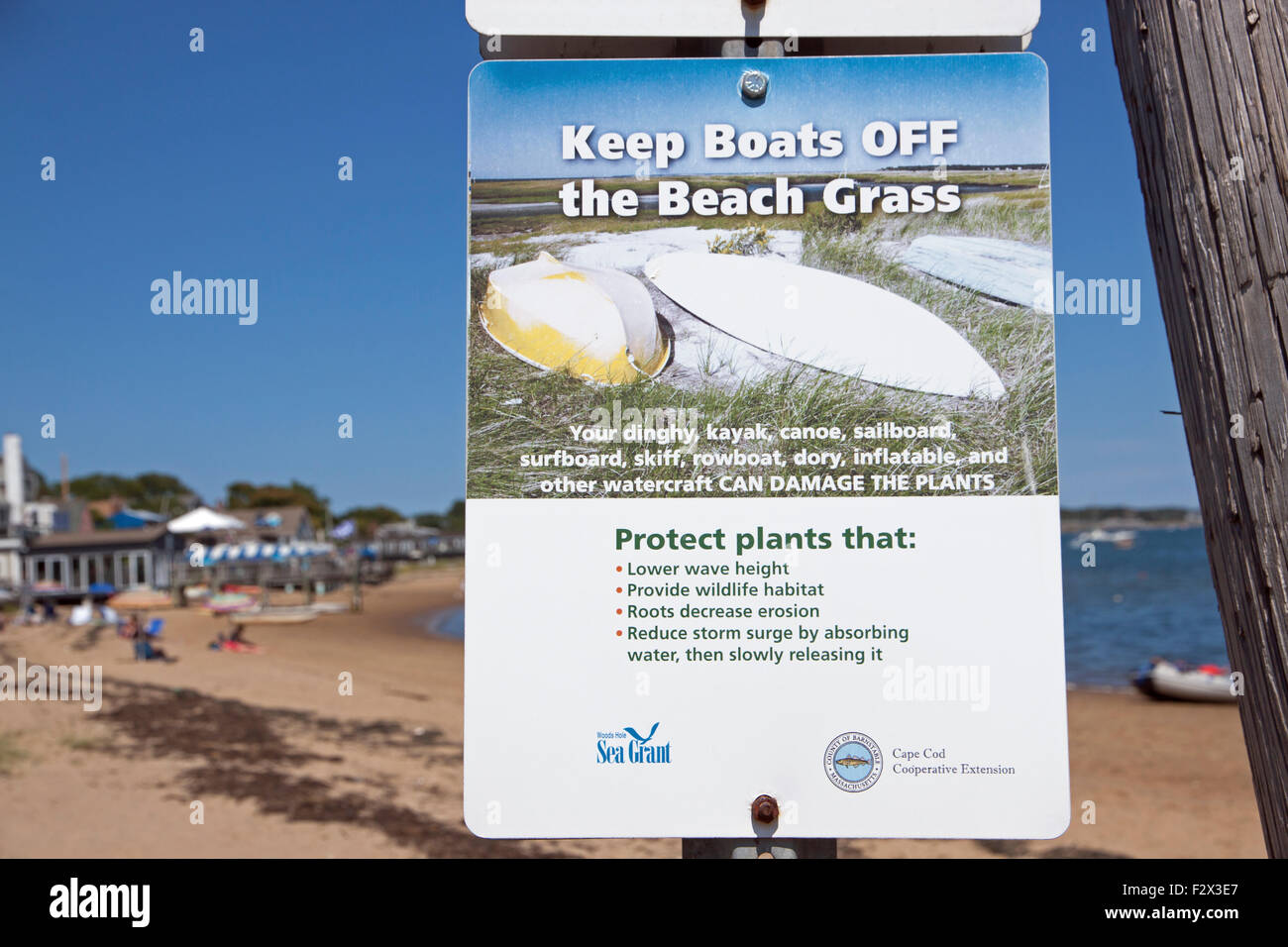 Sign saying to keep boats off of beach grass in order to protect beneficial beach grass. Stock Photo