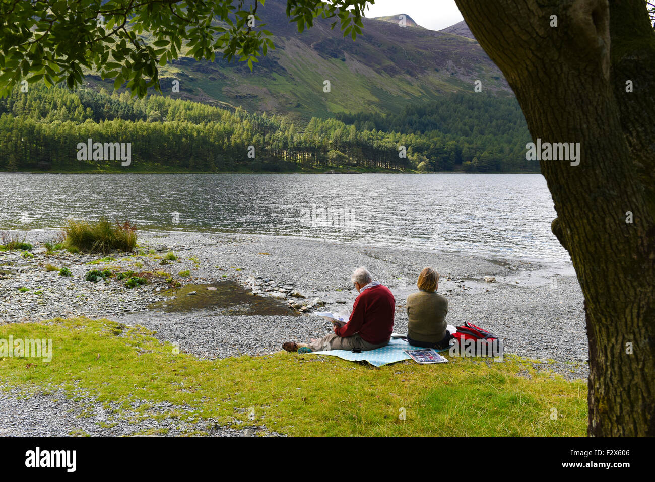 Relaxing and reading by Lake Buttermere, Lake District National Park