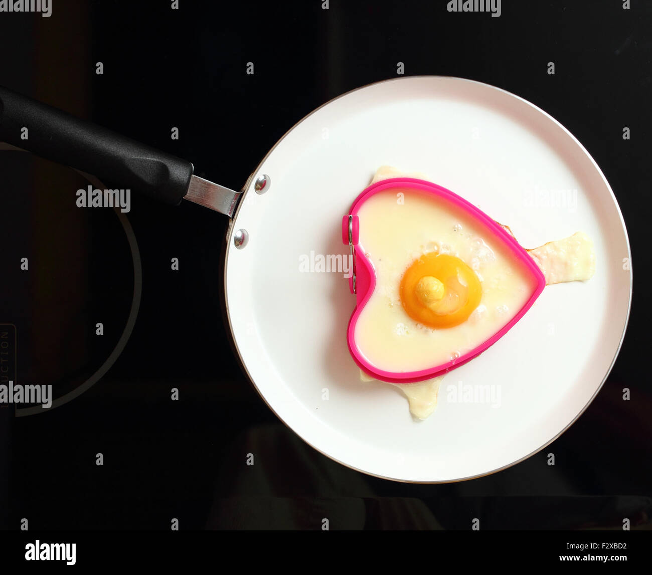 Frying Egg Sunny Side Up in Heart Shape Egg Ring Stock Photo Alamy