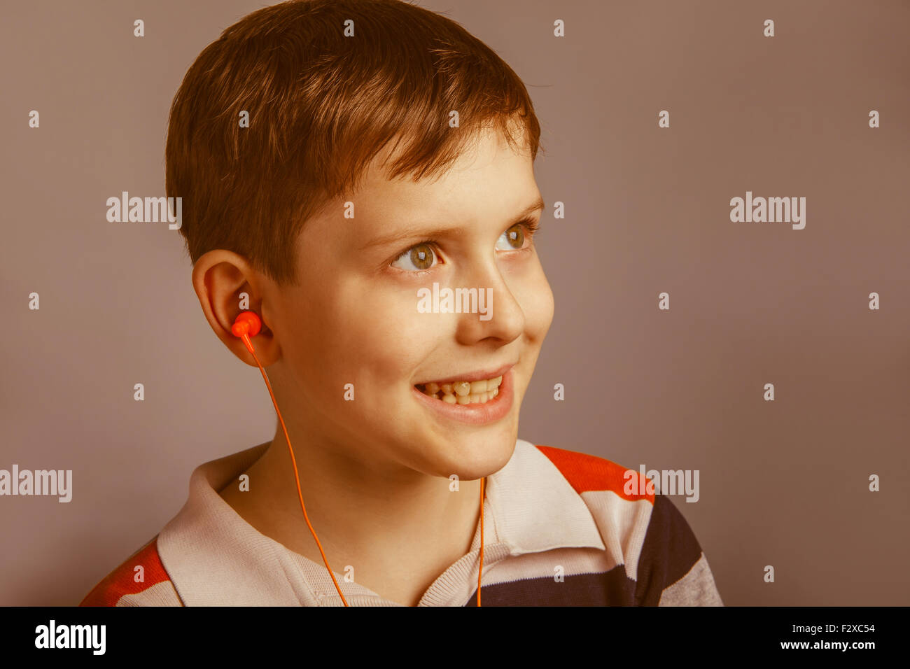 Europeanlooking boy of ten years listening to music with headphones on