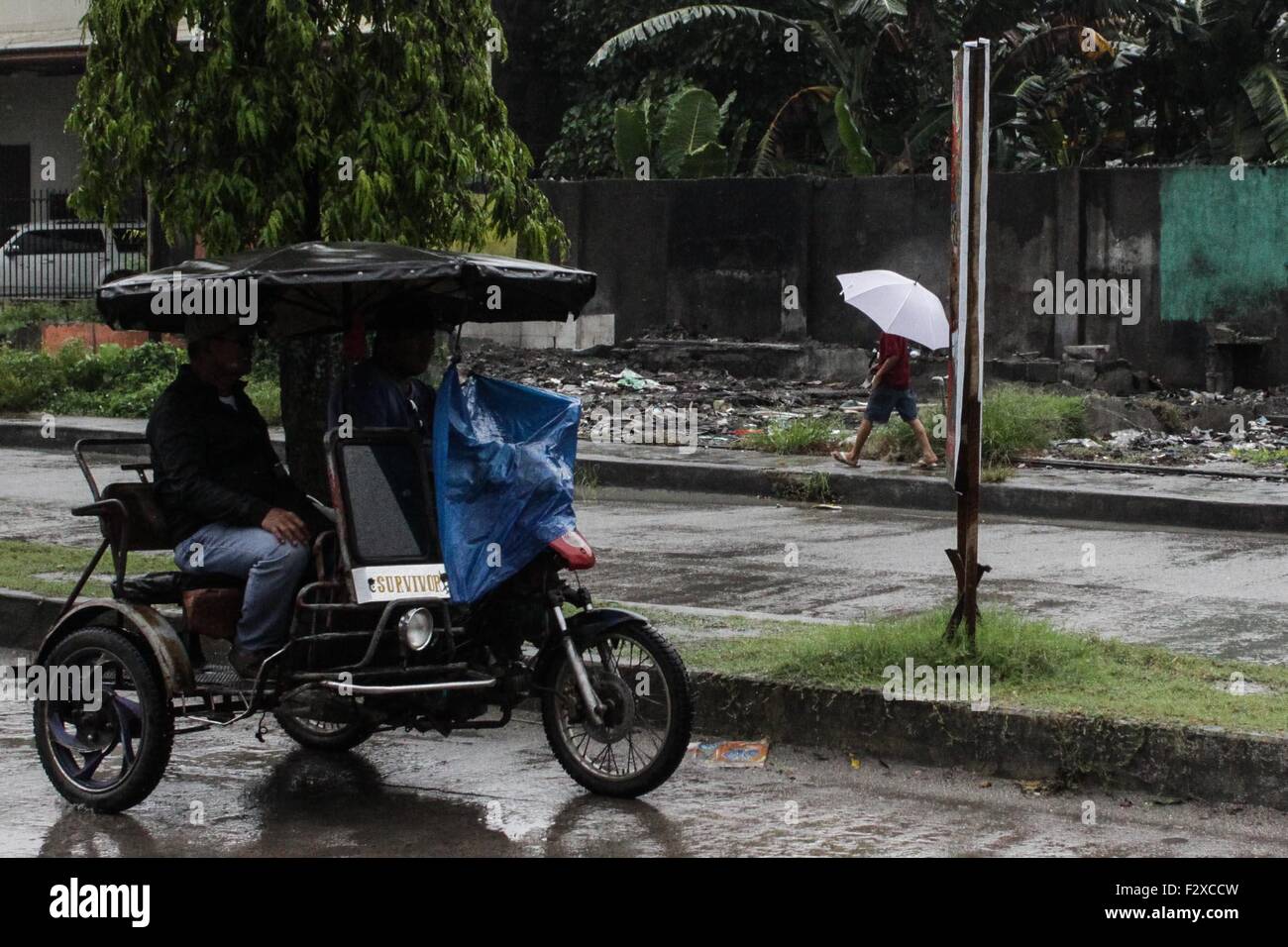 Cotabato, Philippines. 25th Sep, 2015. A Filipino man use umbrella along the street in Cotabato City. According to the Philippine Atmospheric, Geophysical and Astronomical Services Administration (PAGASA), tropical storm Jenny with an international name: Dujuan, is expected to bring monsoon rains from Luzon to Mindanao, as it draws near the country. Maximum sustained winds of 85 kph and gustiness of up to 100 kph, PAGASA believes Jenny might still become a typhoon. Credit:  Dante Dennis V Diosina Jr/Pacific Press/Alamy Live News Stock Photo