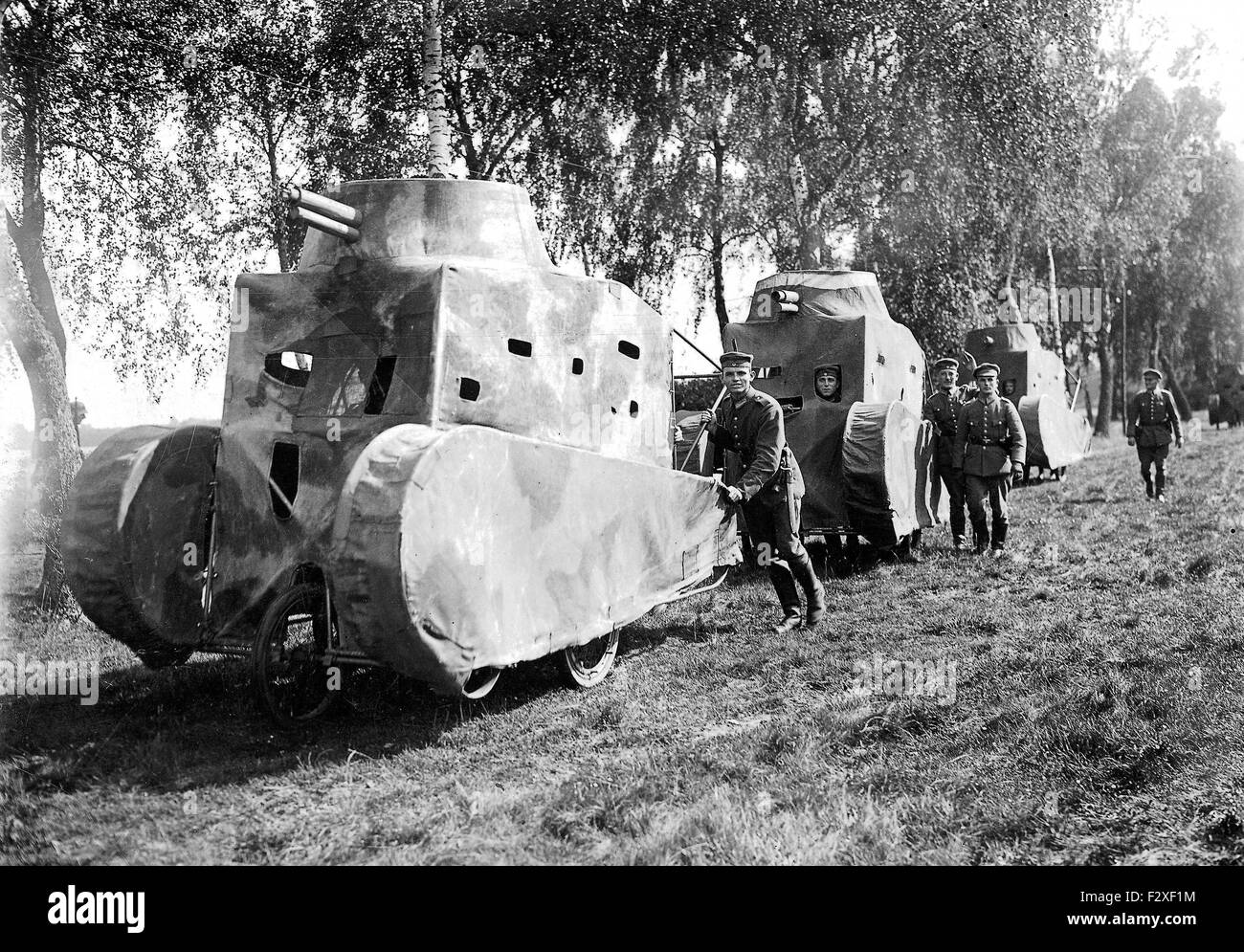 Soldaten der Reichswehr bewegen Nachbildungen von Panzern in einem Manöver, 1926. Da Deutschland nach den Bestimmungen des Versailler Vertrages die Produktion eigener Panzer verboten war, nutzte die Reichswehr Attrappen, um die Panzerabwehr üben zu können. Die Modelle wurden in diesem Fall aus Leinwand auf einem Holzgerüst hergestellt. Stock Photo